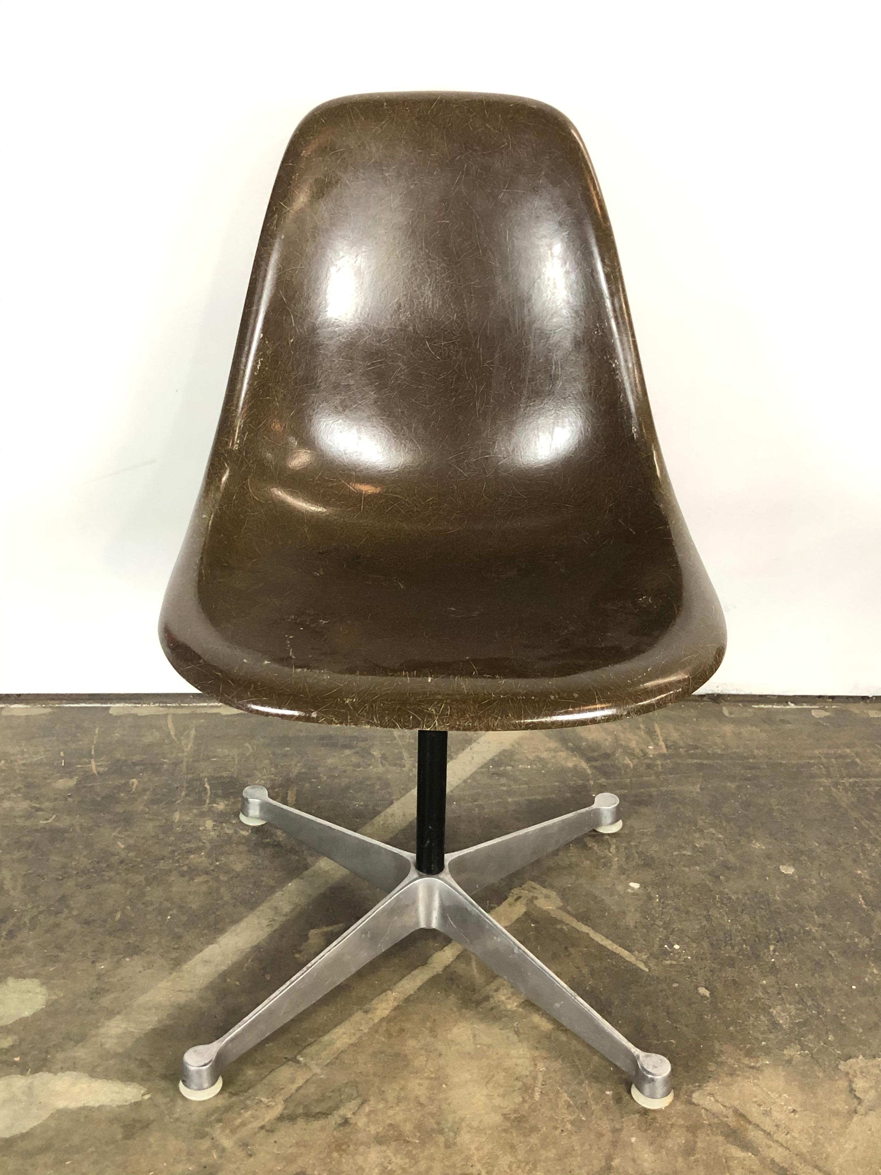Herman Miller Eames fiberglass swivel chair. Signed under shell. Handsome darker neutral tone technically called Seal Brown. No cracks or holes to the shell. Swivels smoothly. Retains all nylon foot glides for use on multiple surfaces. Shell has a