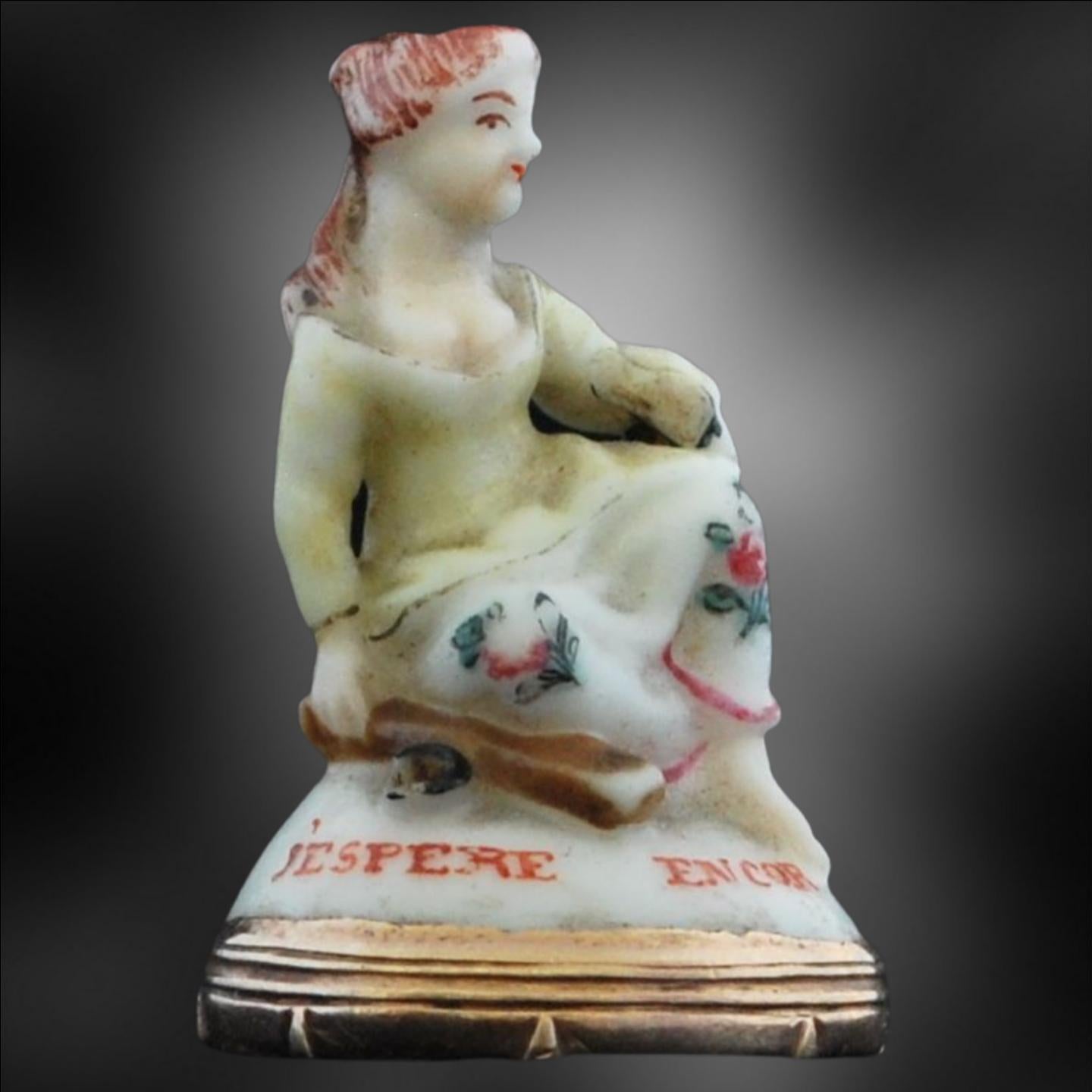 A delightul porcelain seal, depicting a young lady, seated on a mound. It is painted with the motto J'ESPRE ENCORE, or I Still Hope. No doubt this was intended as a gift, to be given by a young man to his sweetheart as a token of his love. 

The
