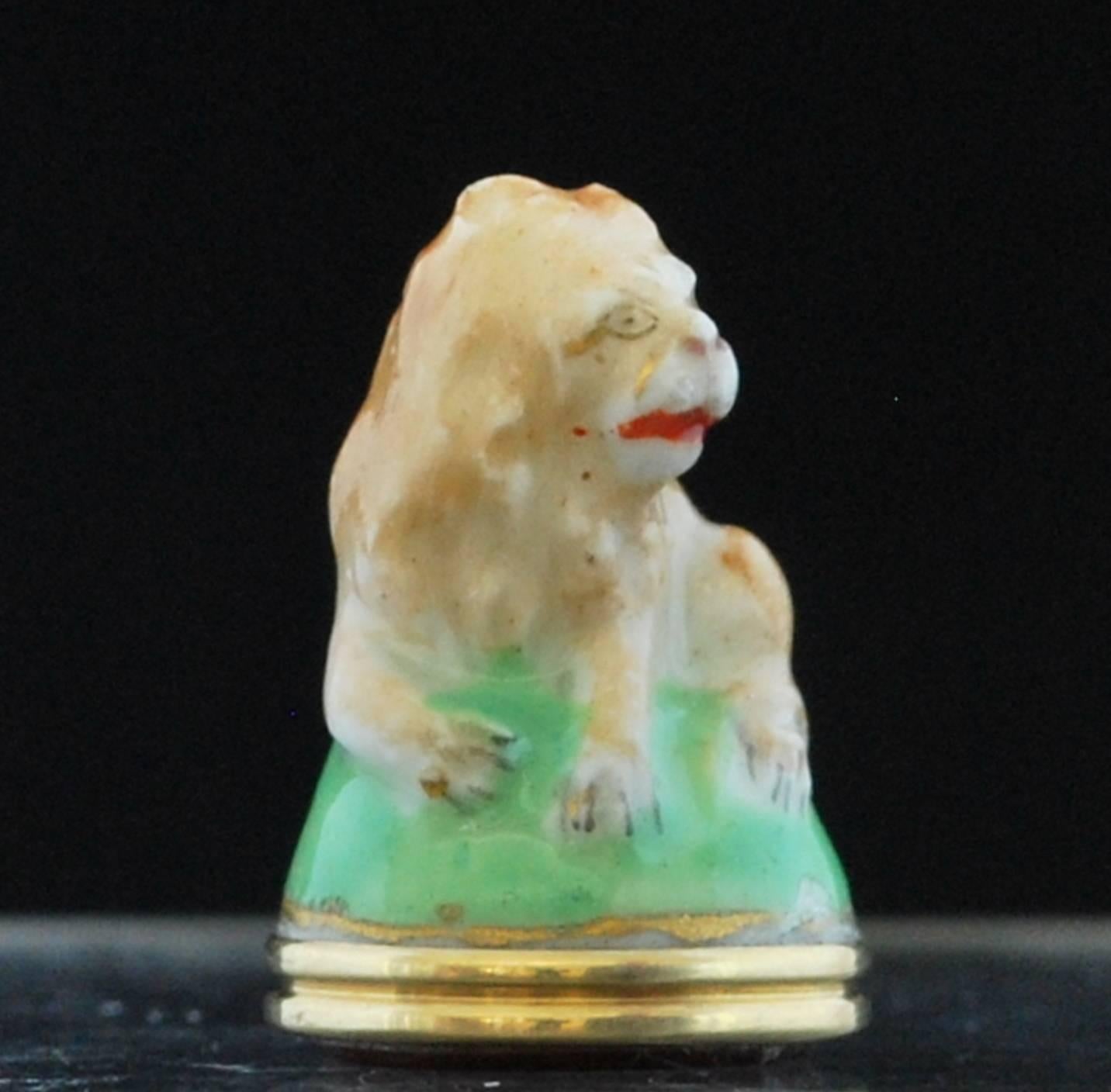 A porcelain seal in for the form of a seated lion. With original gold mount, loop, and semi-precious stone: which has not been engraved.