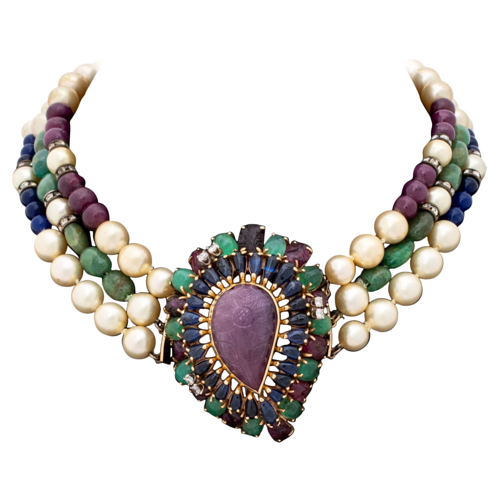 Collana di perle multicolore in oro giallo Seaman Schepps, con una spilla / chiusura staccabile con un rubino a forma di pera intagliato incastonato al centro del castone del peso di circa 48,00 carati, ornato da venticinque zaffiri blu cabochon a