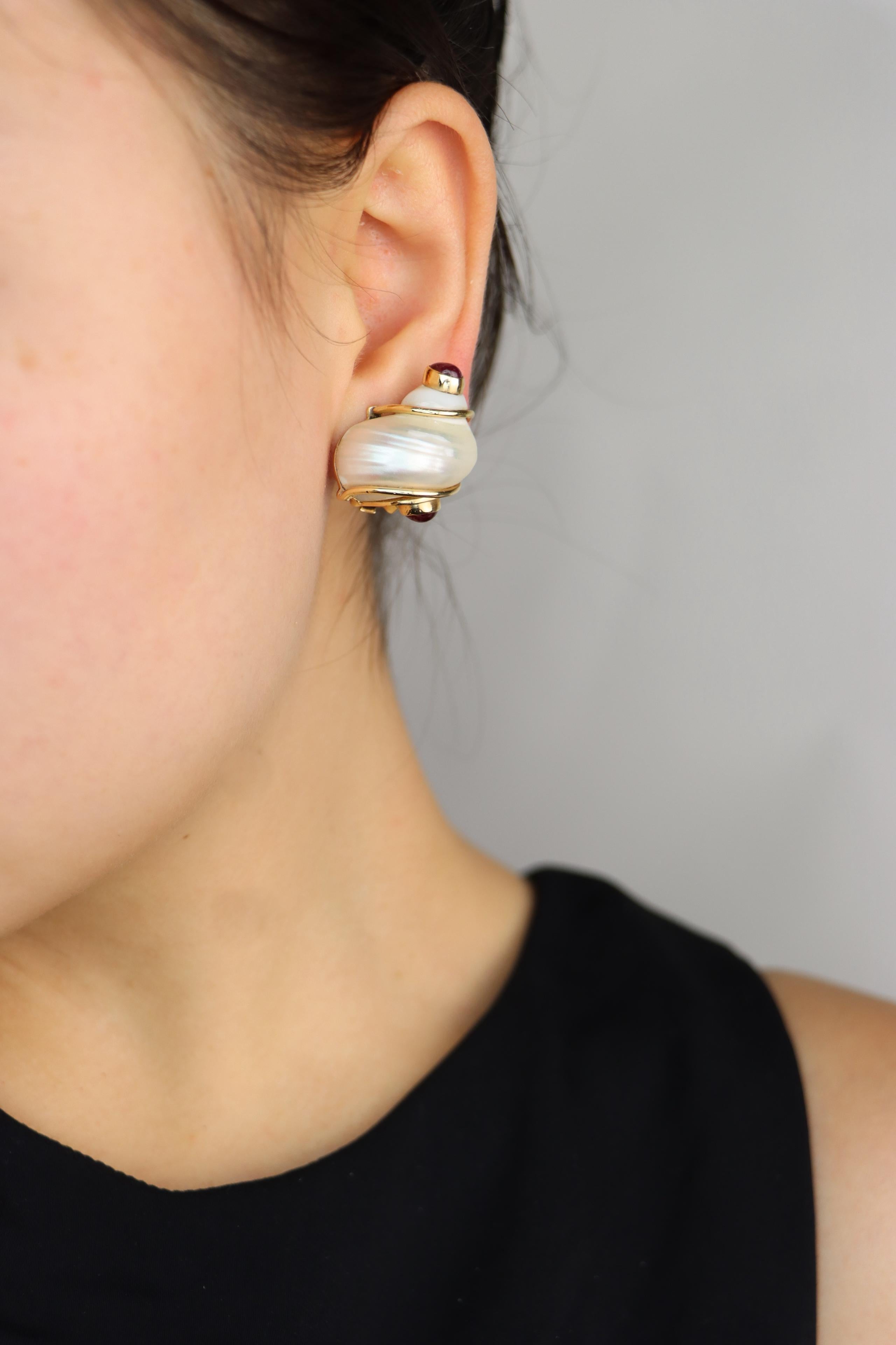 Orecchini con conchiglia Seaman Schepps in oro 14 carati con rubino turbo

Contrassegnato:
P.S.I.V.A.
Seaman Schepps
14K

Dimensioni approssimative:
2,5 cm (lunghezza)  
2,1 cm (larghezza) 
21 grammi di peso.