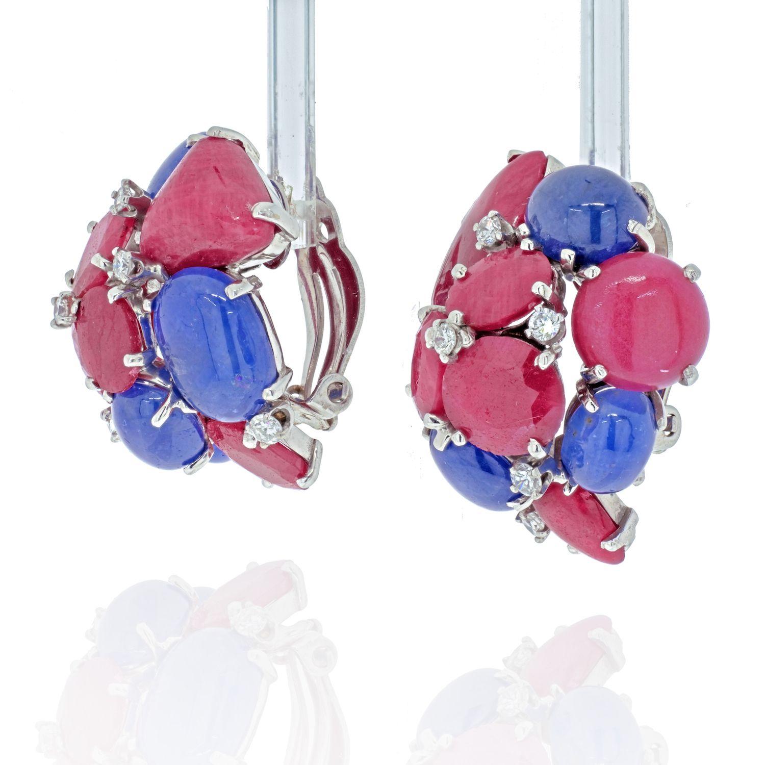 Seaman Schepps earrings of cluster design, set with cabochon sapphires and faceted and cabochon rubies, enhanced by round brilliant-cut diamonds, circa 1970s.
Signed P.S.V. of Seaman Schepps.

Length: 1 ¼ x 1 ins