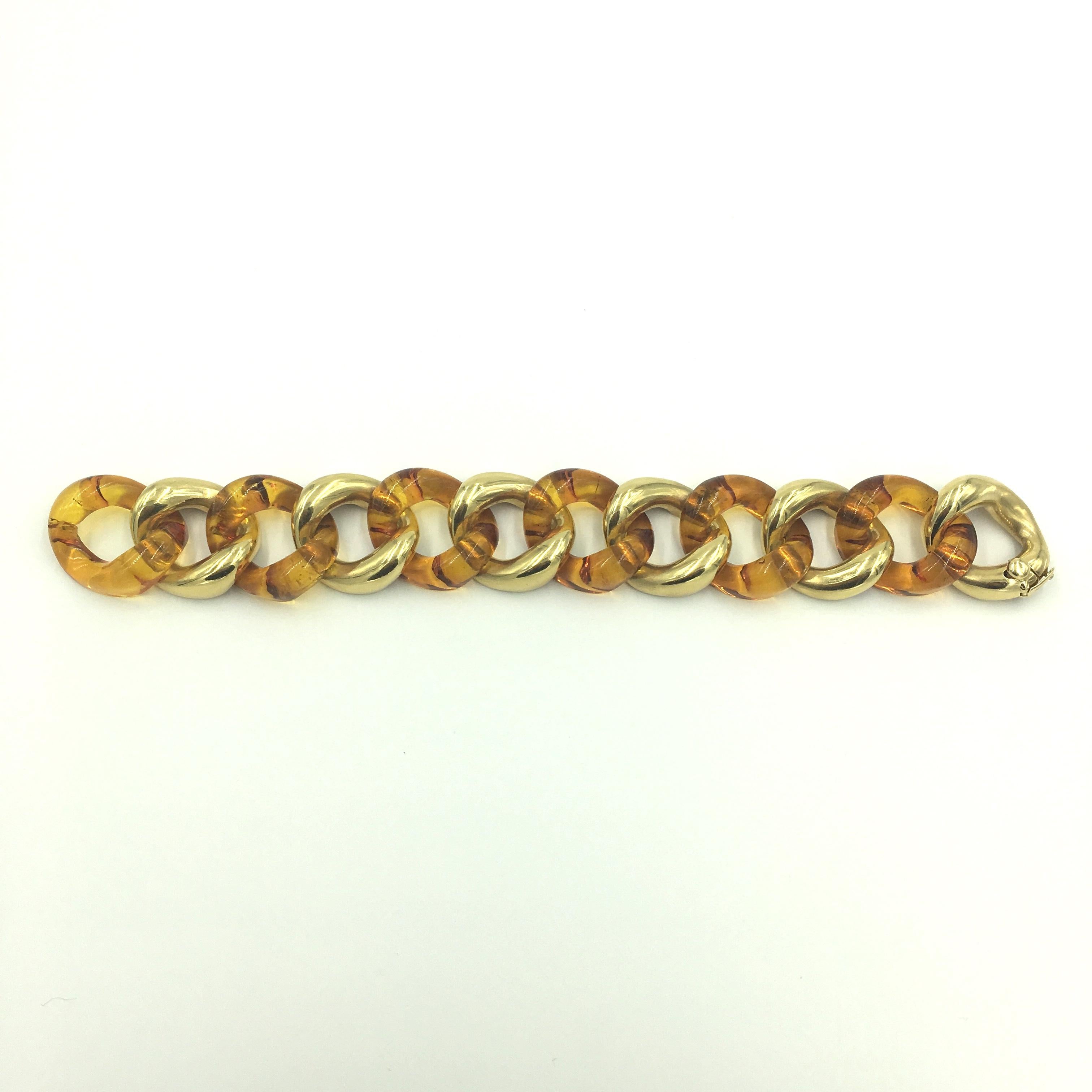 An 18 karat yellow gold and amber link bracelet. Seaman Schepps. Medium size. Designed as alternating polished gold curbed links and amber links. Width is approximately 1 inch, length is approximately 7 3/4 inches, gross weight is approximately 61.6
