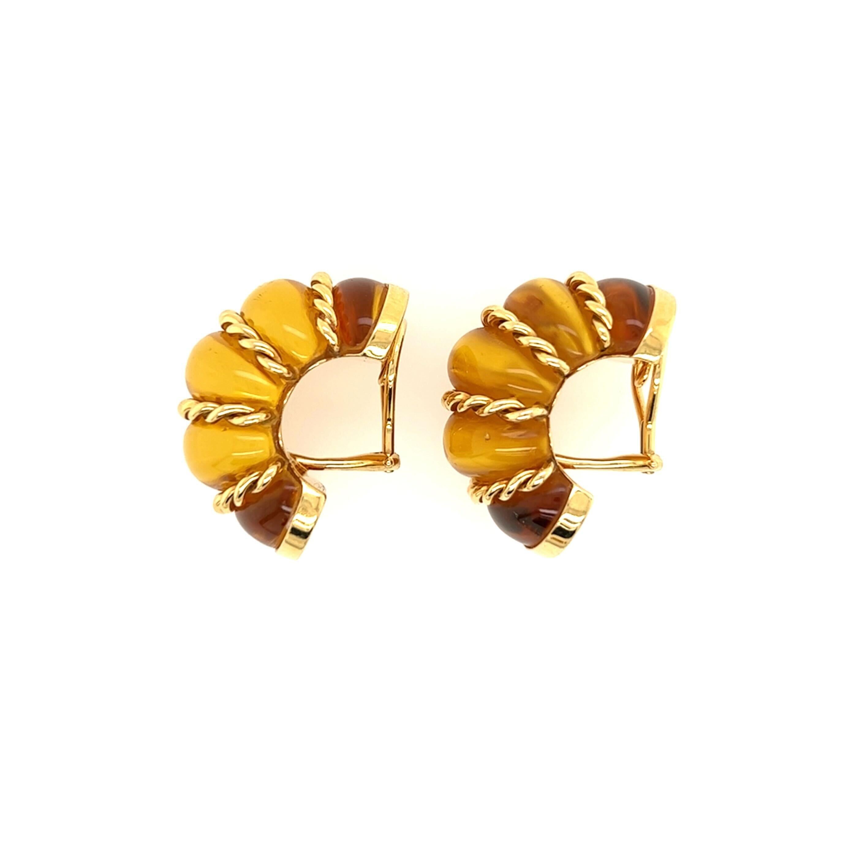 A pair of 18 karat yellow gold and amber earclips, Seaman Schepps.  The “Shrimp” earclips formed of scalloped amber half hoops horizontally striped with ropework gold.  Length approximately 1 1/4 inches.  Gross weight approximately 28.50 grams. 