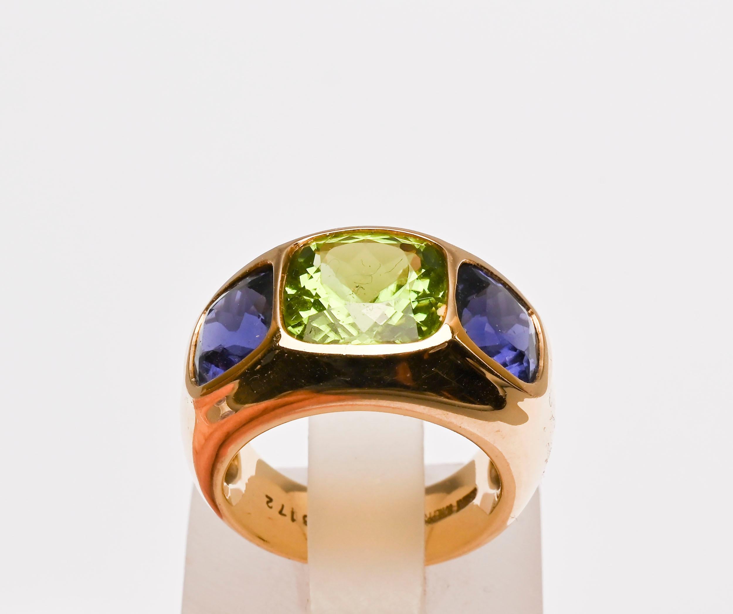 Seaman Schepps three stone flush mounted ring. The center stone is a peridot measuring 7/16