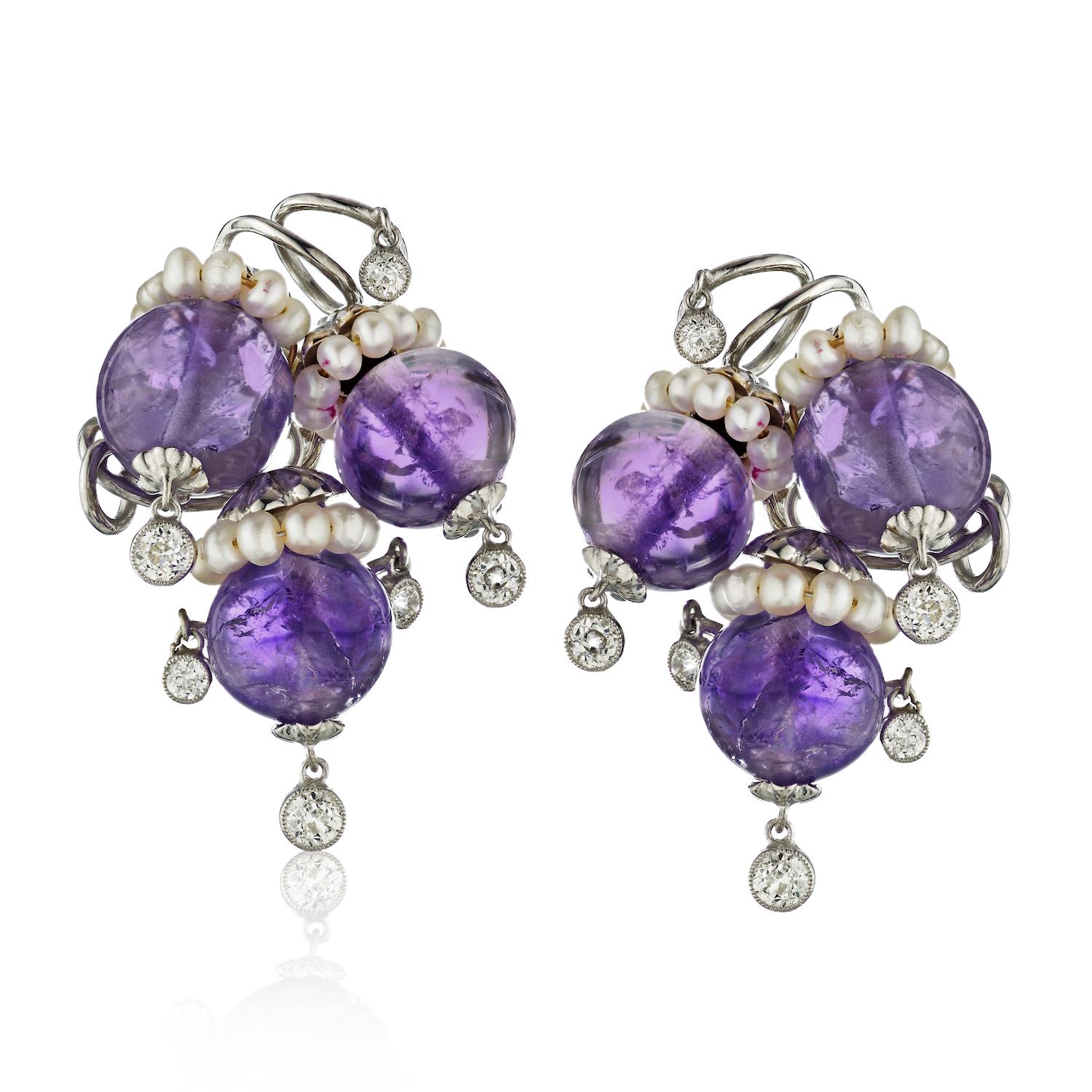 Pair of White Gold, Amethyst, Diamond and Pearl Clip-Earrings, each designed as a cluster of grapes, bezel-set old European-cut diamond fringe setting.
6 amethyst beads ap. 13.4 to 12.9 mm., 11 old European-cut diamonds ap. 1.35 cts., signed Seaman