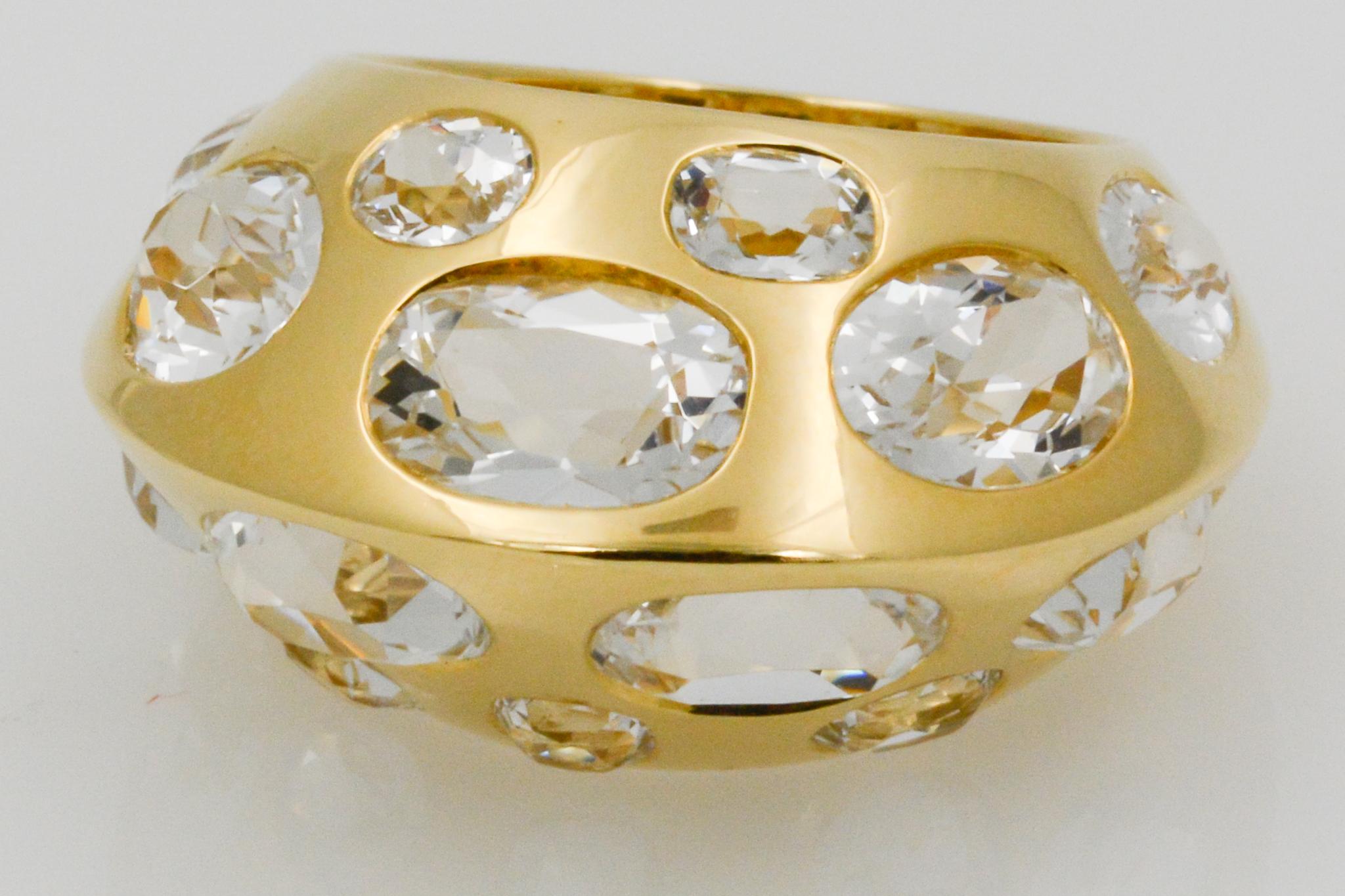 This Seaman Schepps Antibes ring is adorned in 18k yellow gold and features 14 oval white topaz. The ring has a domed peak design and is signed Seaman Schepps. The ring is currently a size six, and can be sized one (1) size up or down.