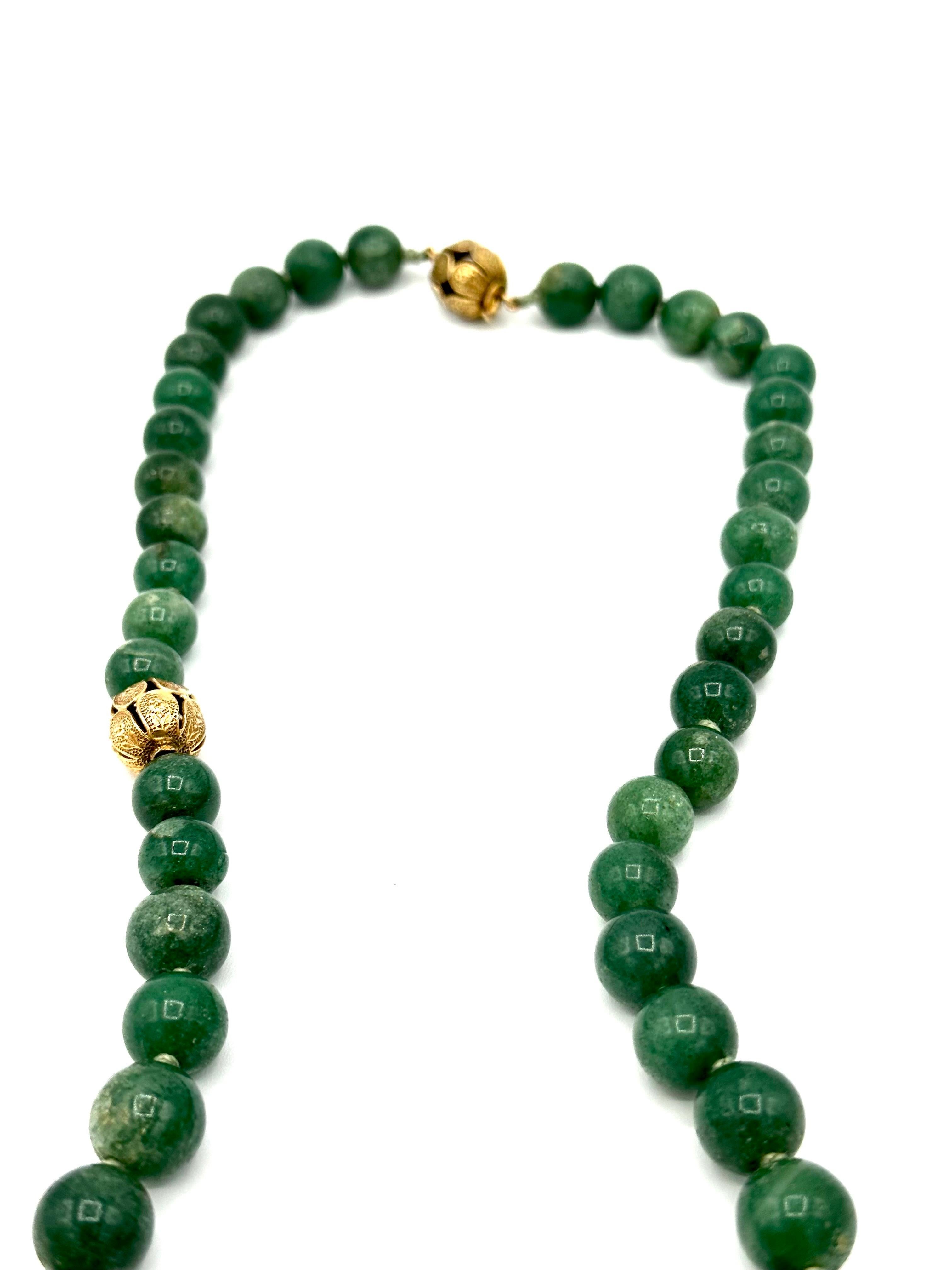 A rare to find beaded Aventurine long necklace designed by Seaman Schepps.  The Aventurine beads are separated by hand crafted 14K yellow gold rondelles depicting floral patterns.  The necklace features one very large carved Aventurine bead, to be