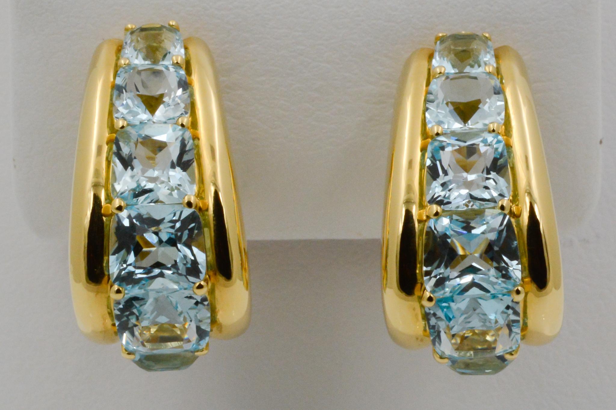 From Seaman Schepps, these 18k yellow gold Madison hoop earrings feature 14 blue topaz. The earrings have clip backs and are signed Seaman Schepps.