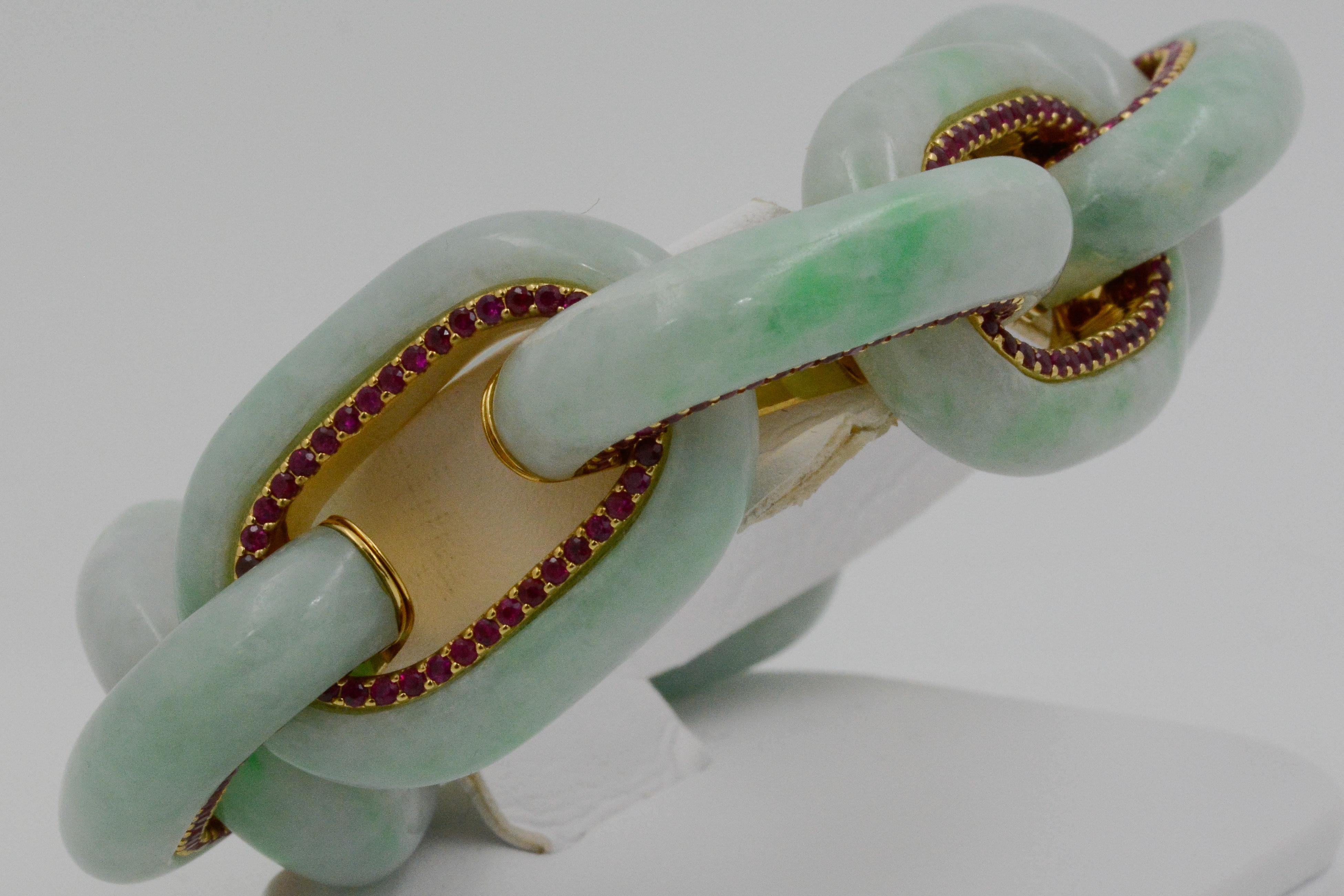 This Seaman Schepps bodrum jadeite 18k yellow gold link bracelet is accented with round faceted rubies. The large links of jade create a classic statement piece. The bracelet is signed and has a polished finish and an integrated clasp. 