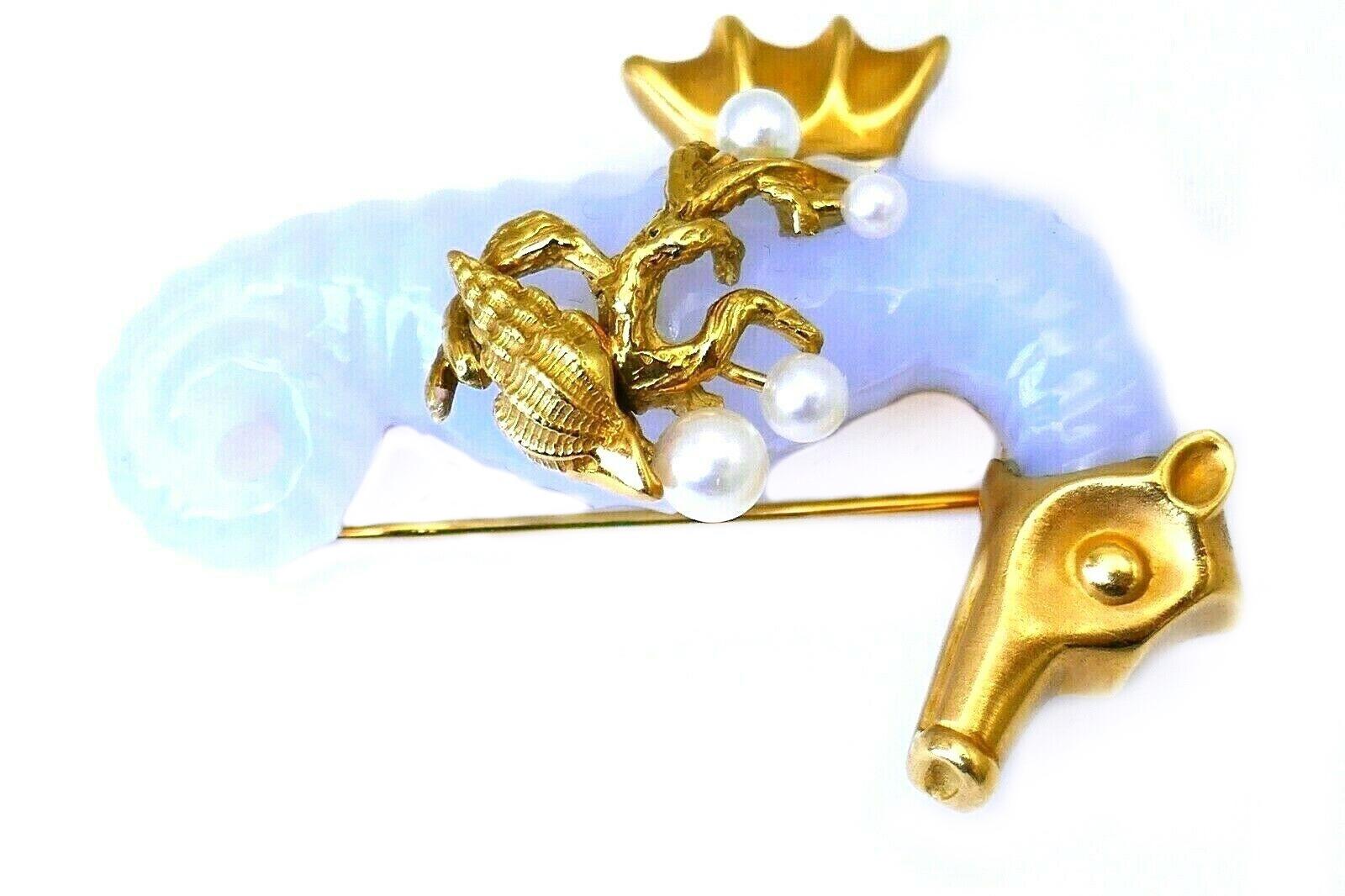 A beautiful Seahorse brooch by Seaman Schepps. 
Made of carved chalcedony and 18k yellow gold, featuring pearl. Stamped with Seaman Schepps maker's mark, a hallmark for 18k gold and a serial number.
Measurements: 2