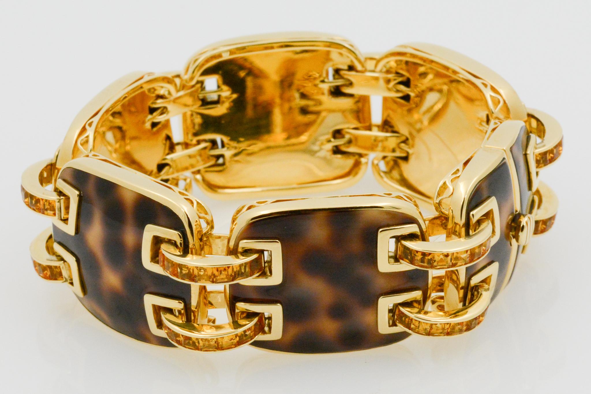 From Seaman Schepps, this 18k yellow gold Cowrie Ponte bracelet features five full square cushion shape cowrie links and two halves forming the clasp. The bracelet features 12 double connector bars, each channel is set with square faceted baguette