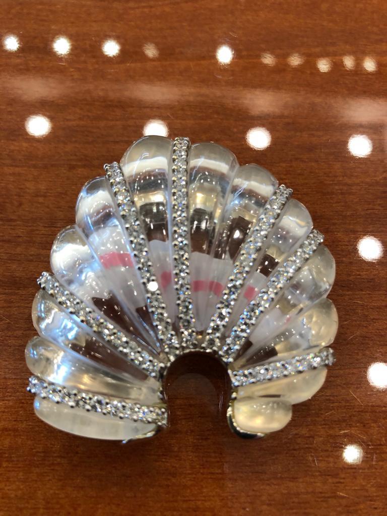 An exquisite brooch by Seam Schepps, crafted as a carved crystal with brilliant diamond accents mounted in 18k white gold, signed Seaman Schepps.
Approx. 2 1/4″ x 2″