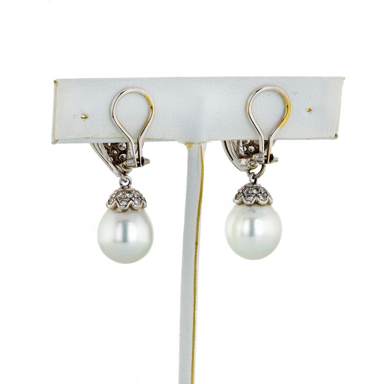 Lustrous South Sea pearls exhibiting a soft silvery grey with pink and purple opalescence are suspended from similarly-shaped diamond tops. The earrings have a sophisticated and important look, but their organic freeform is soft and feminine. 

They