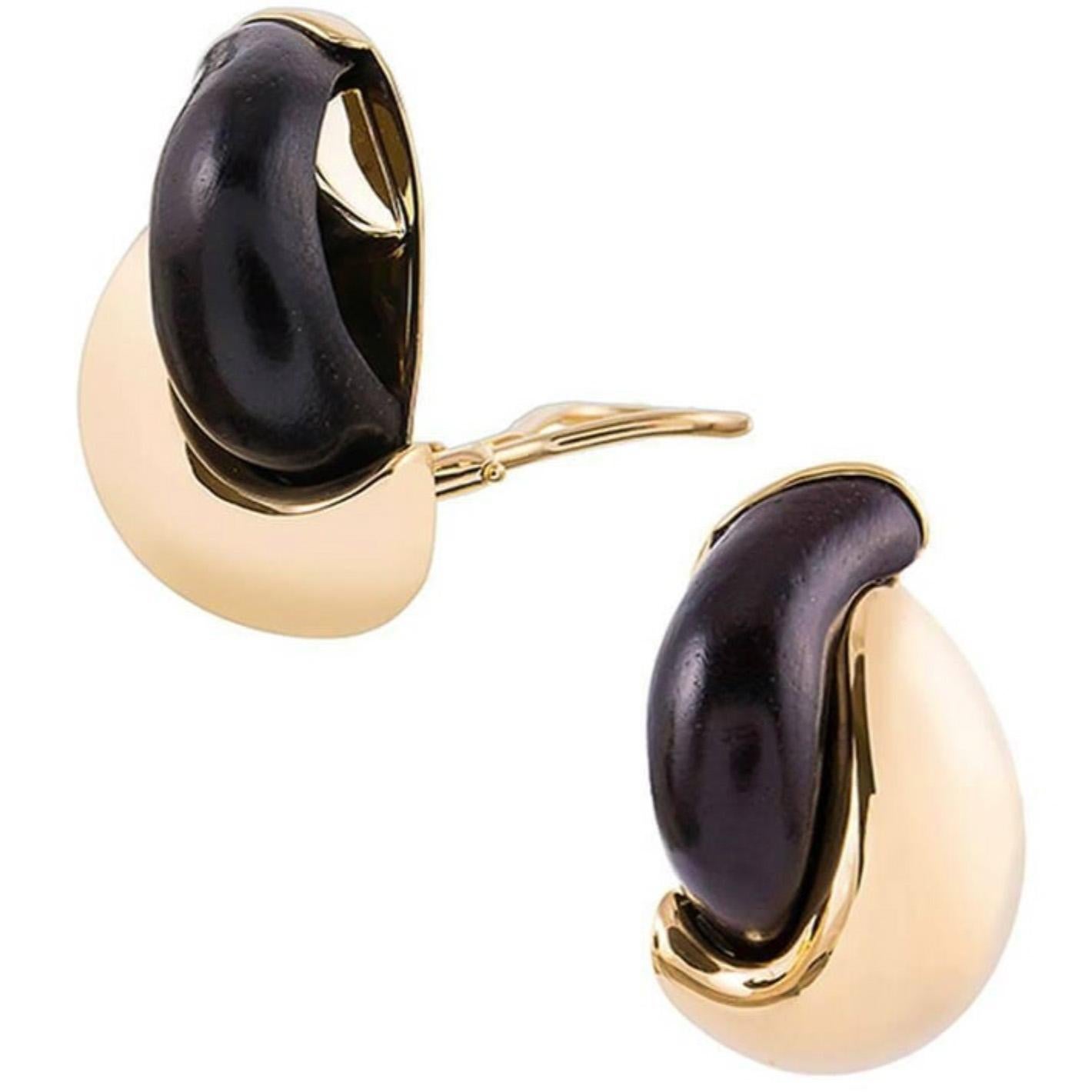 A sophisticated take on a classic hoop design, compliments of iconic American jeweler Seaman Schepps. Sensuously curved ebony sits nestled symbiotically by a sweeping stroke of 18k yellow gold. 1 1/8 inch tall and 5/8 inch wide. Currently clips,