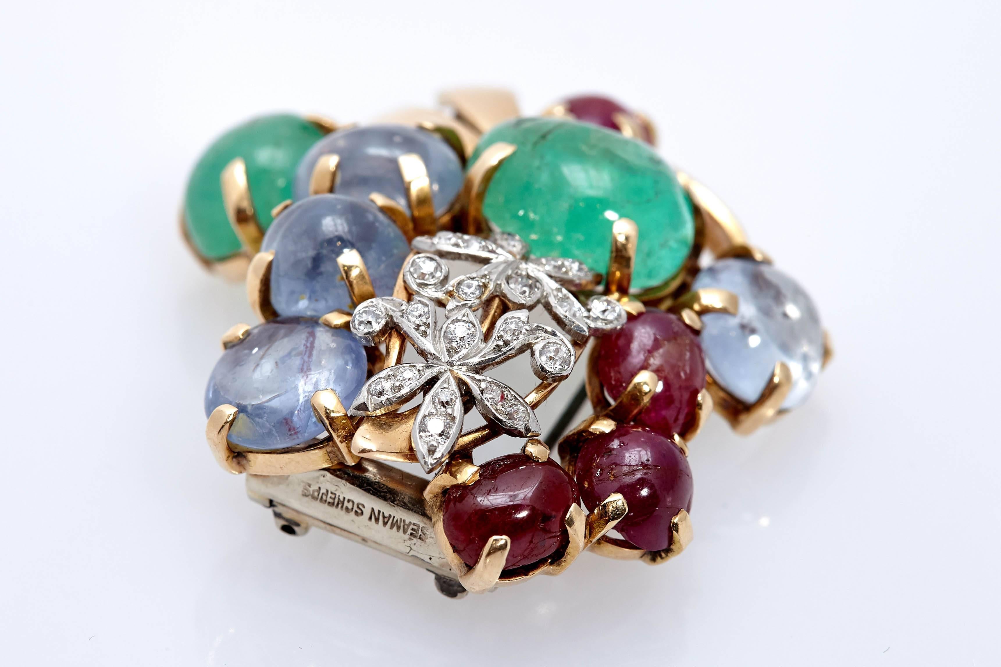 A Seaman Schepps floral brooch in 18kt yellow gold with cabochon emerald, sapphires and rubies, highlighted with diamonds. Made in the United States, circa 1970s.