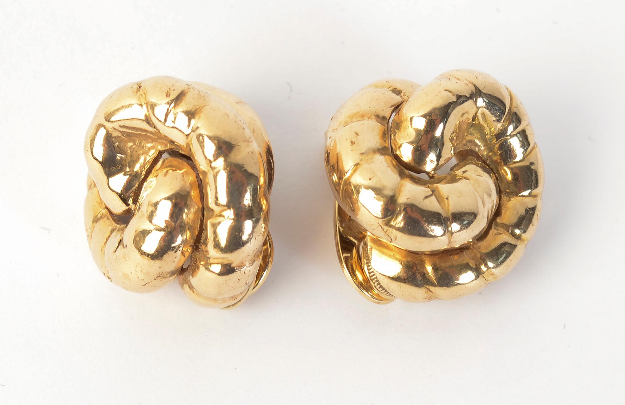 Two half circles hug each other in these 14 karat gold earrings by Seaman Schepps. Each half circle has several striations for a bit of texture.
The earrings have clip backs that can be converted to posts. Schepps worked in 14 karat gold until the