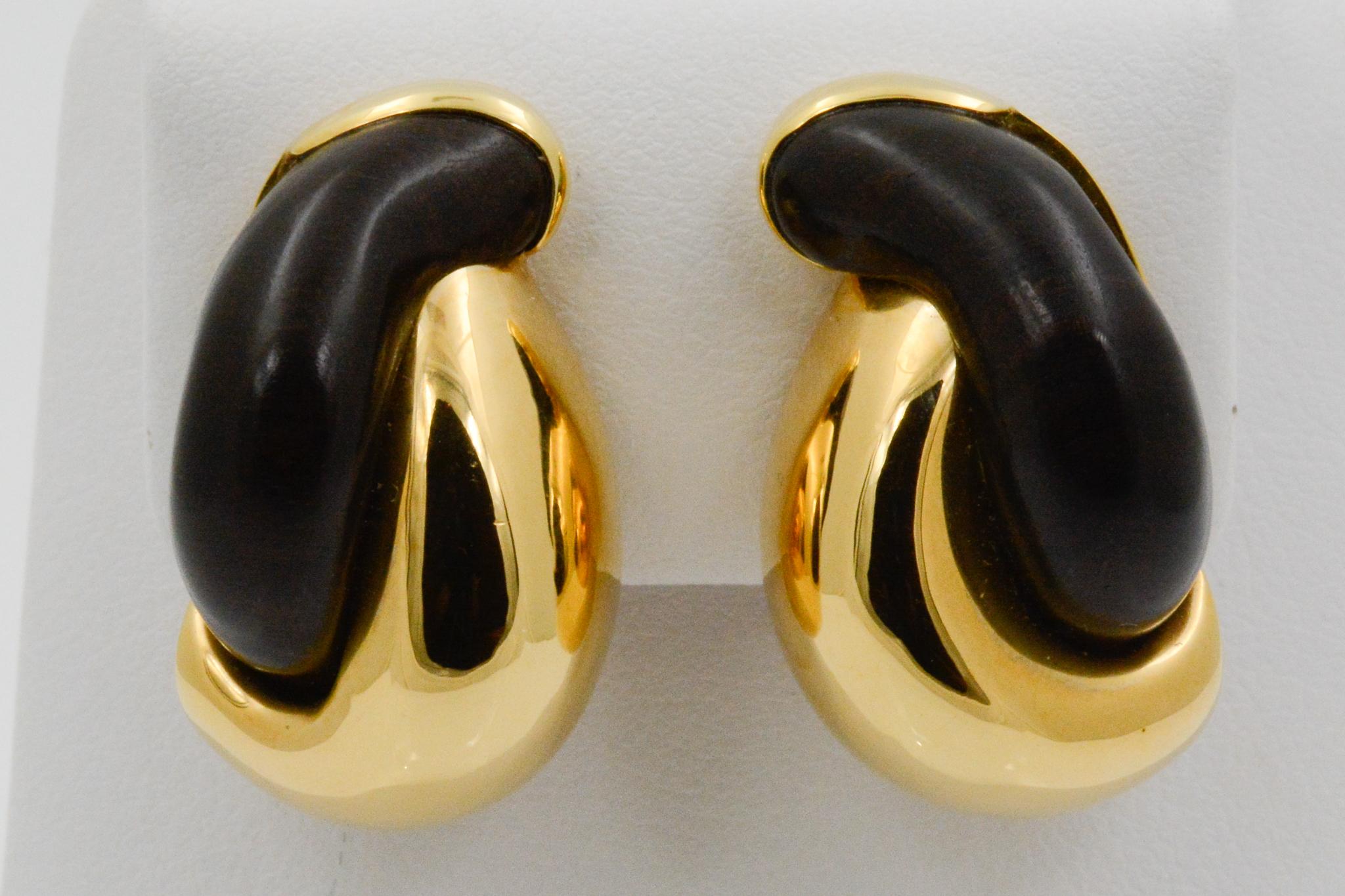 From Seaman Schepps, these half link clip earrings feature intertwining 18 karat yellow gold and ebony wood. Signed Seaman Schepps. 