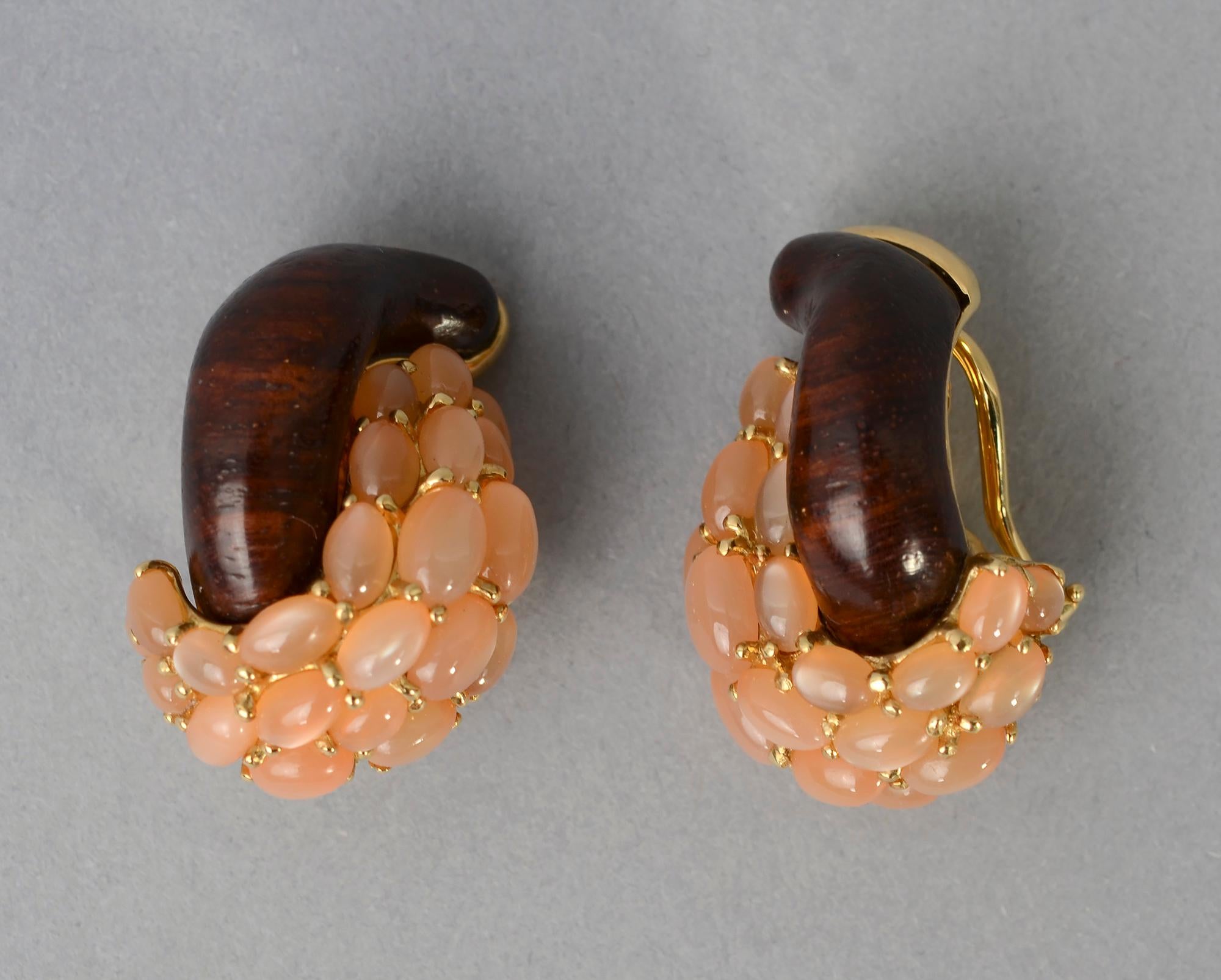 Elegant and unusual pink moonstone and wood (probably ebony) half link earrings by Seaman Schepps.
The pink moonstones are a wonderfully warm color that plays off beautifully with the wood. Clip backs can be converted to posts. 18 karat gold with
