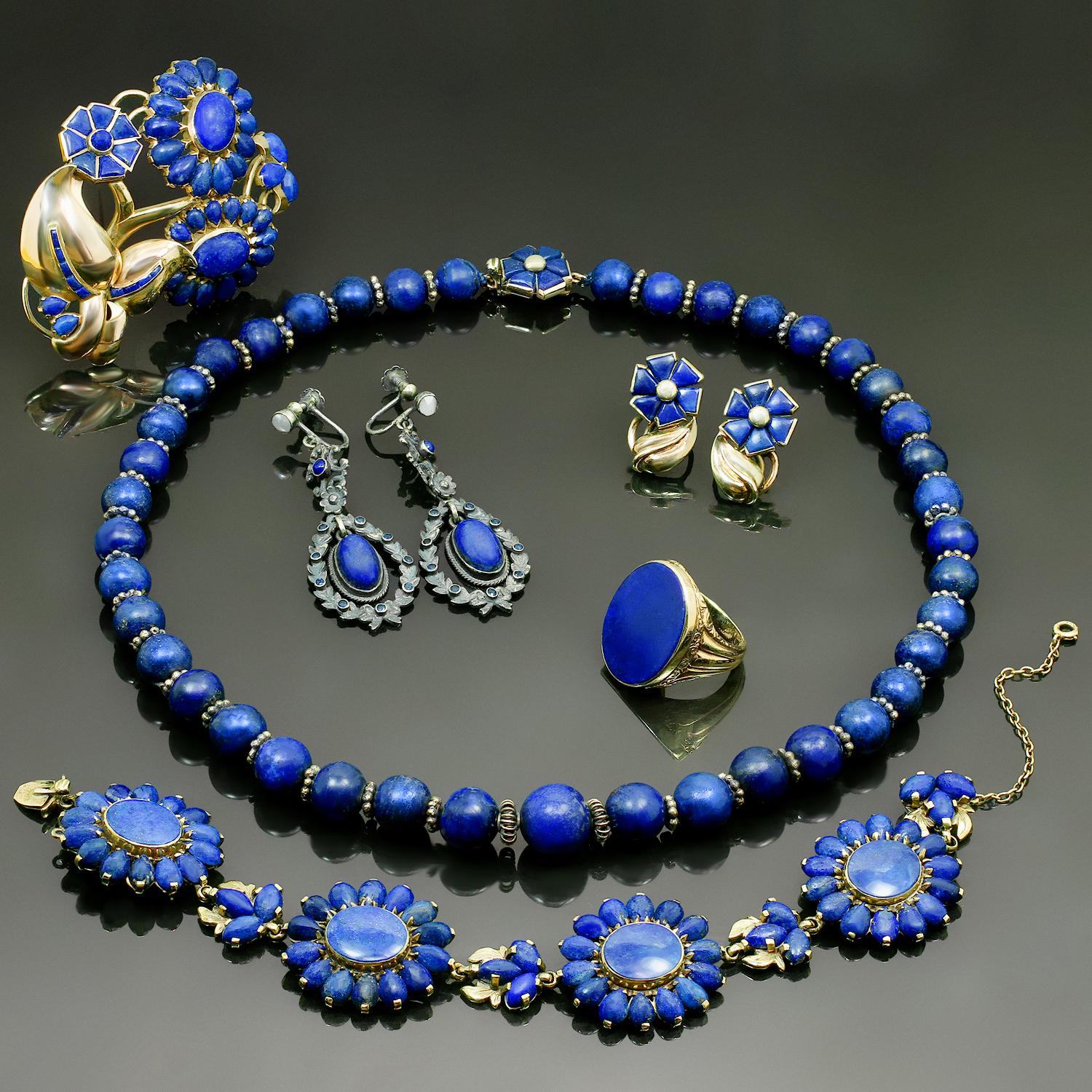 This rare and spectacular Seaman Schepps vintage jewelry suite consists of a beaded necklace, a link bracelet, a floral brooch, a pair of drop earrings, a pair of floral earrings, and a cocktail ring. All the pieces are beautifully set with lapis