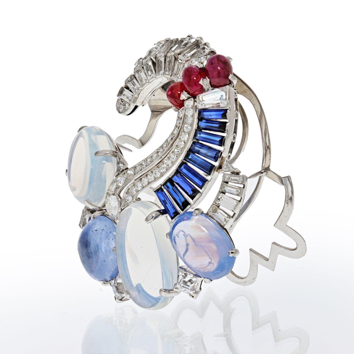 Absolutely stunning and one of a kind Seaman Schepps brooch with moonstone, diamonds, sapphires and rubies. Crafted from 18K white gold with 14K white gold clip. Lively color gemstones such as two large cabochon moonstones approx. 26.00 carats