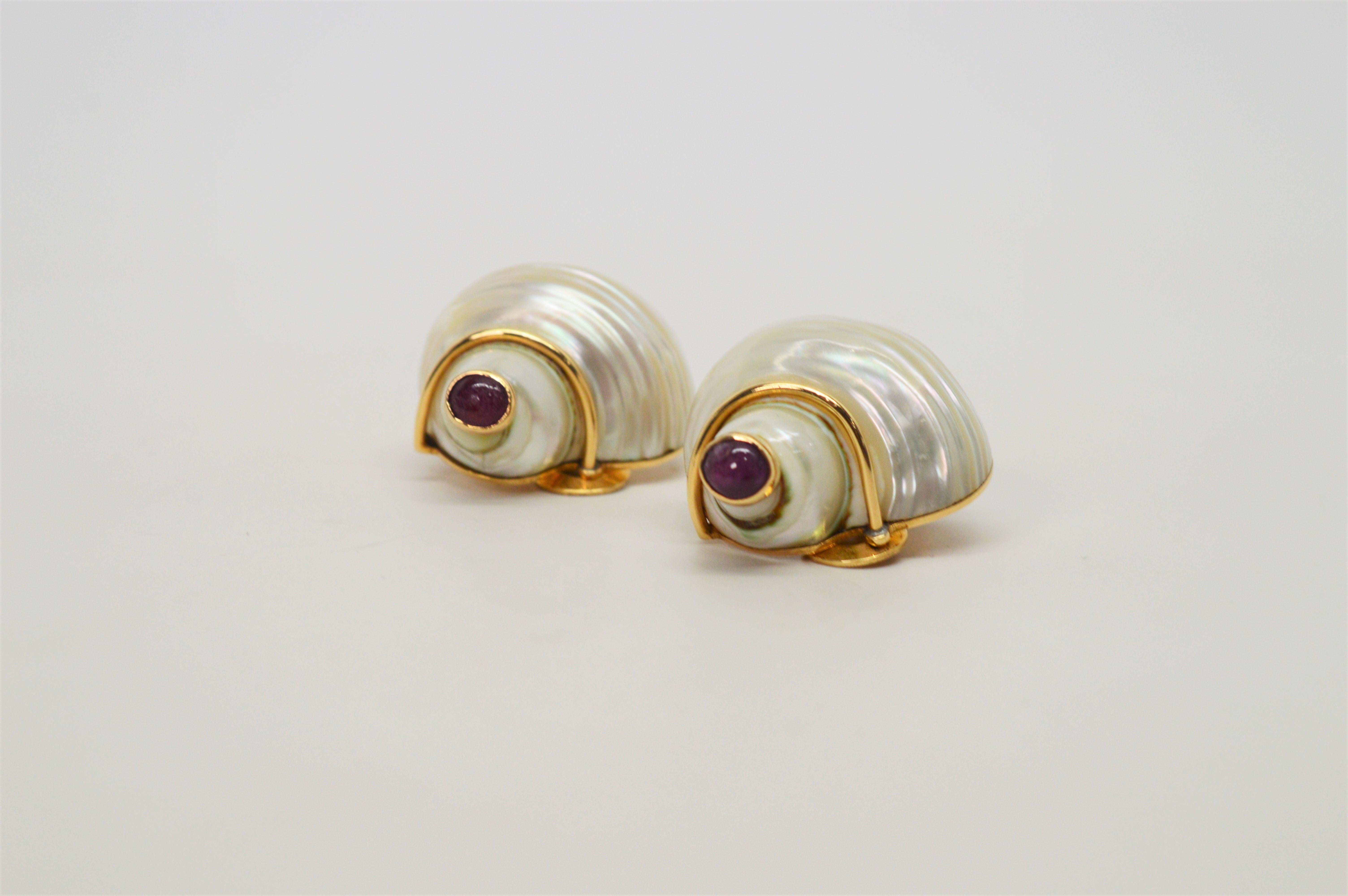 Similar to a design made for Coco Channel and the Duchess of Windsor, these elegant clip style shell earrings are of mother of pearl mounted on and displayed with fourteen karat gold. Four 4 mm ruby cabochons in gold bezel setting adorn this pair