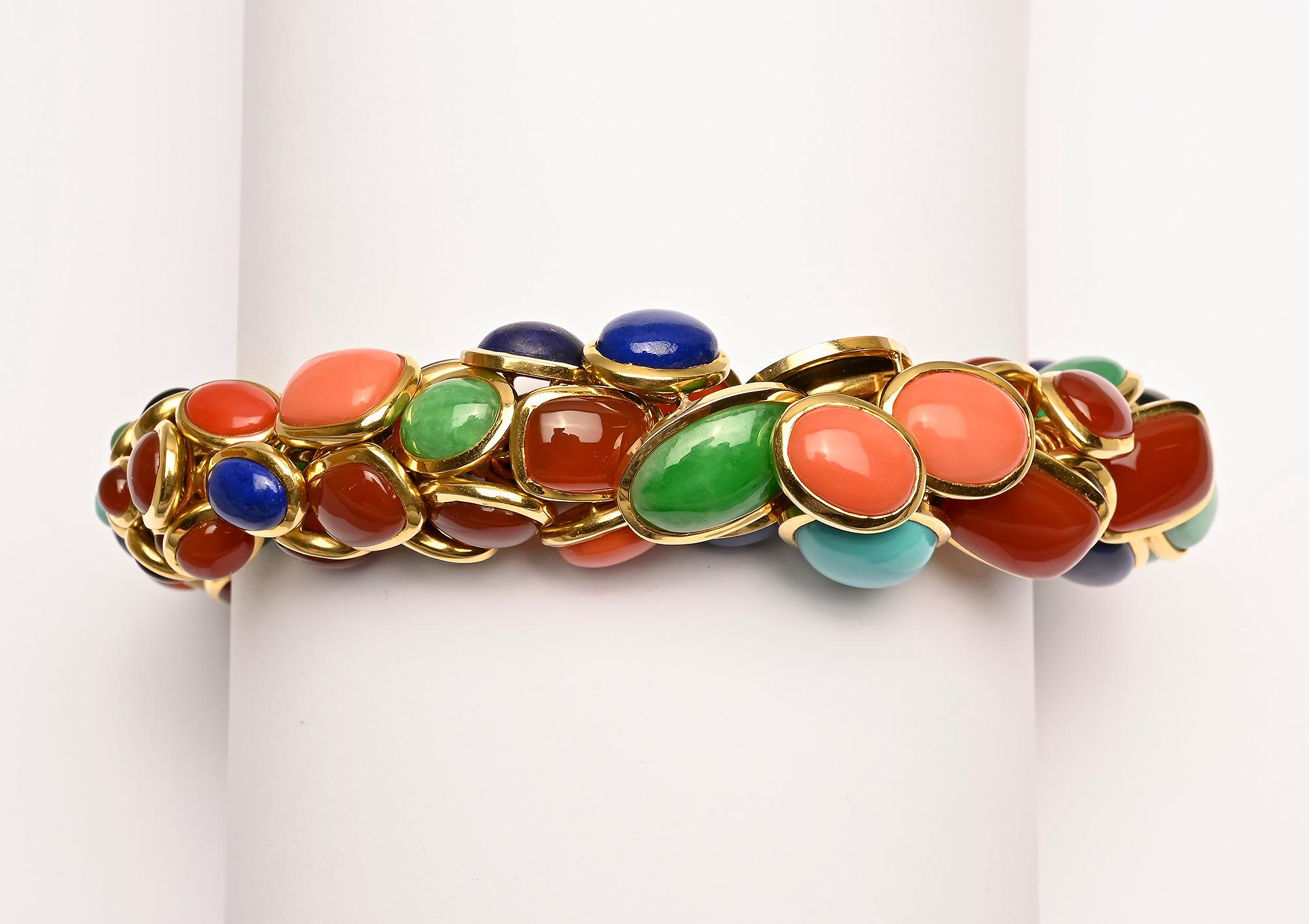 Stunning and most unusual multistone bracelet by Seaman Schepps. Lapiz lazuli; coral; cat's eye; jade; onyx and carnelian are set in round, oval and rectangular bezels creating a rounded and colorful form. When closed, the inner  diameter is 2 1/2