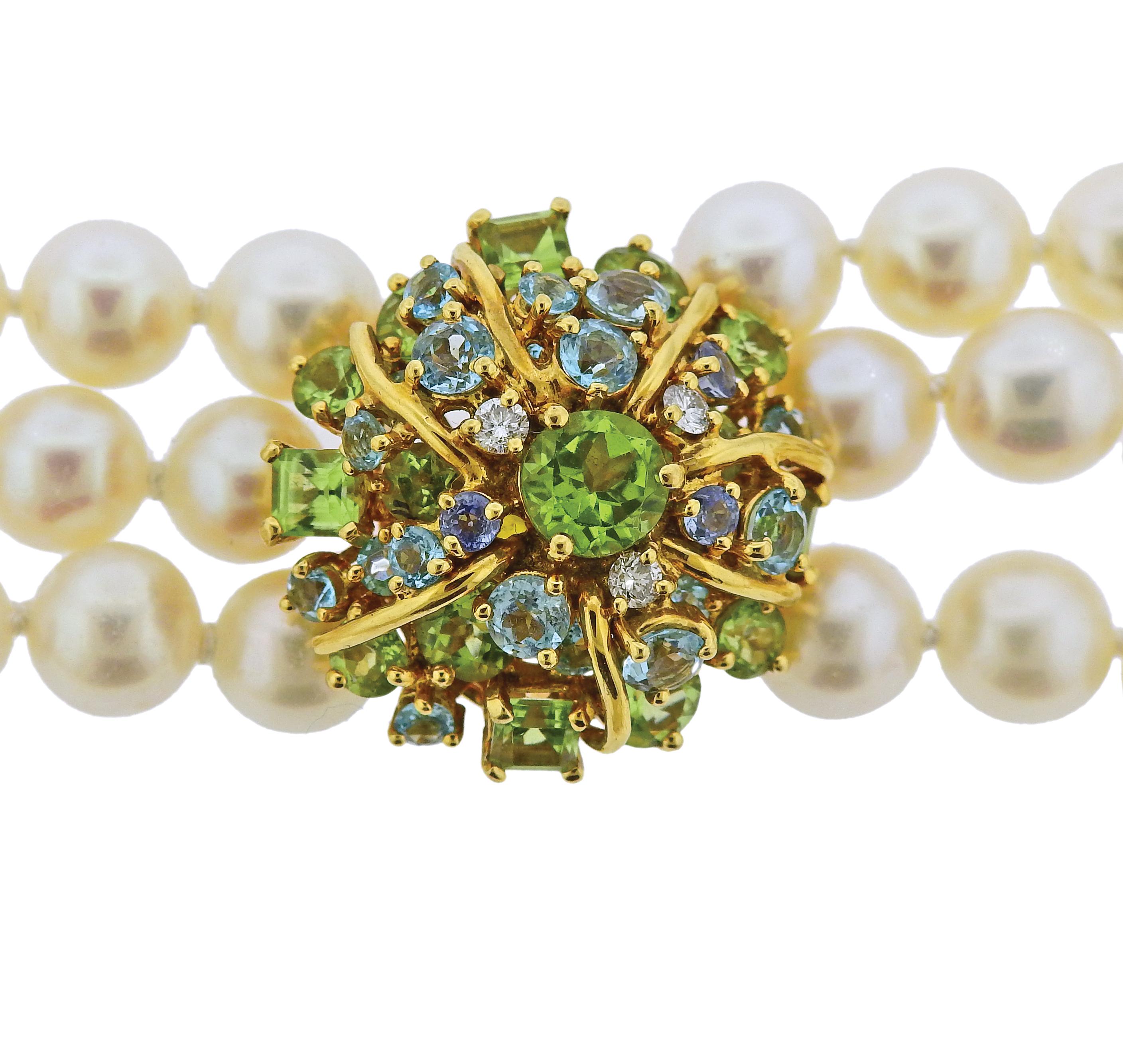 Impressive multi strand necklace by Seaman Schepps, featuring 8 - 8.5mm pearls, as well as multi gemstone clasp, set with peridots, aquamarines and approx. 0.18ctw in G/VS diamonds. Retail $14650. Necklace is 17