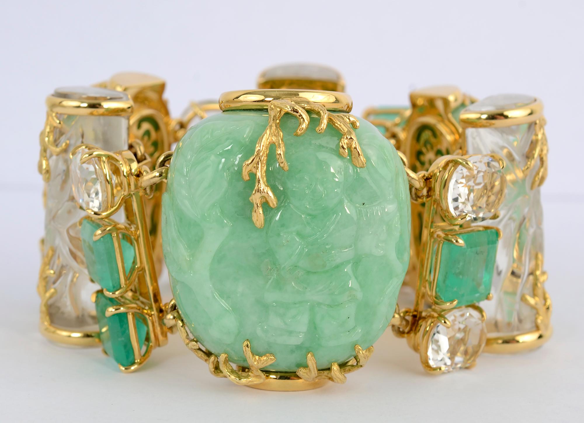 This massive and unusual Seaman Schepps bracelet consists of three jadeite jade snuff bottles alternating with carved rock crystal columns that are accented with gold overlay leaf designs. These panels are joined by square cut emeralds and faceted