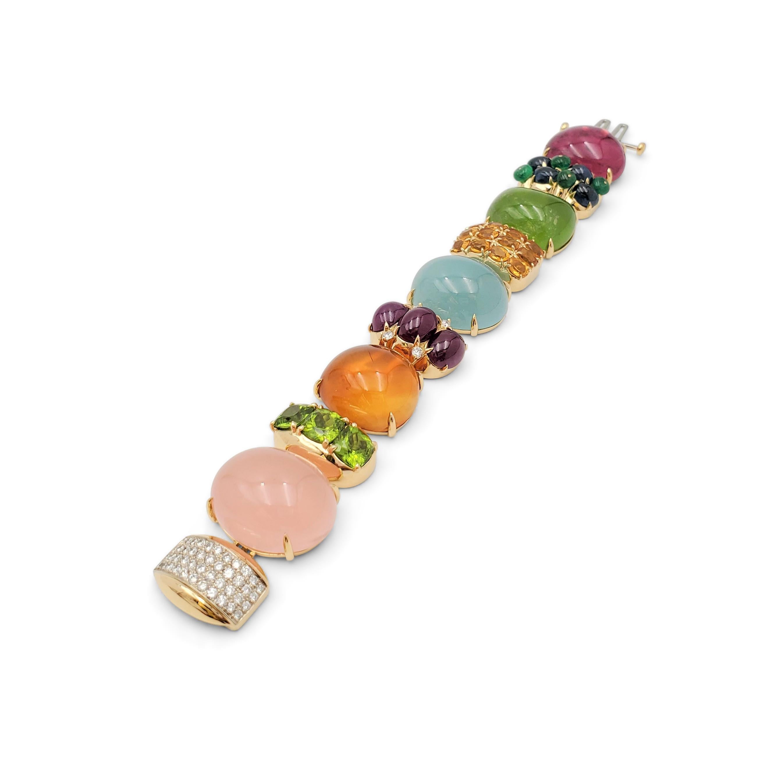 Authentic playful Seaman Schepps bracelet from the Rio collection. Crafted in 18 karat yellow gold, the bracelet is comprised of ten links set with five large tourmaline, peridot, chalcedony, citrine, and rose quartz cabochons, separated by blue