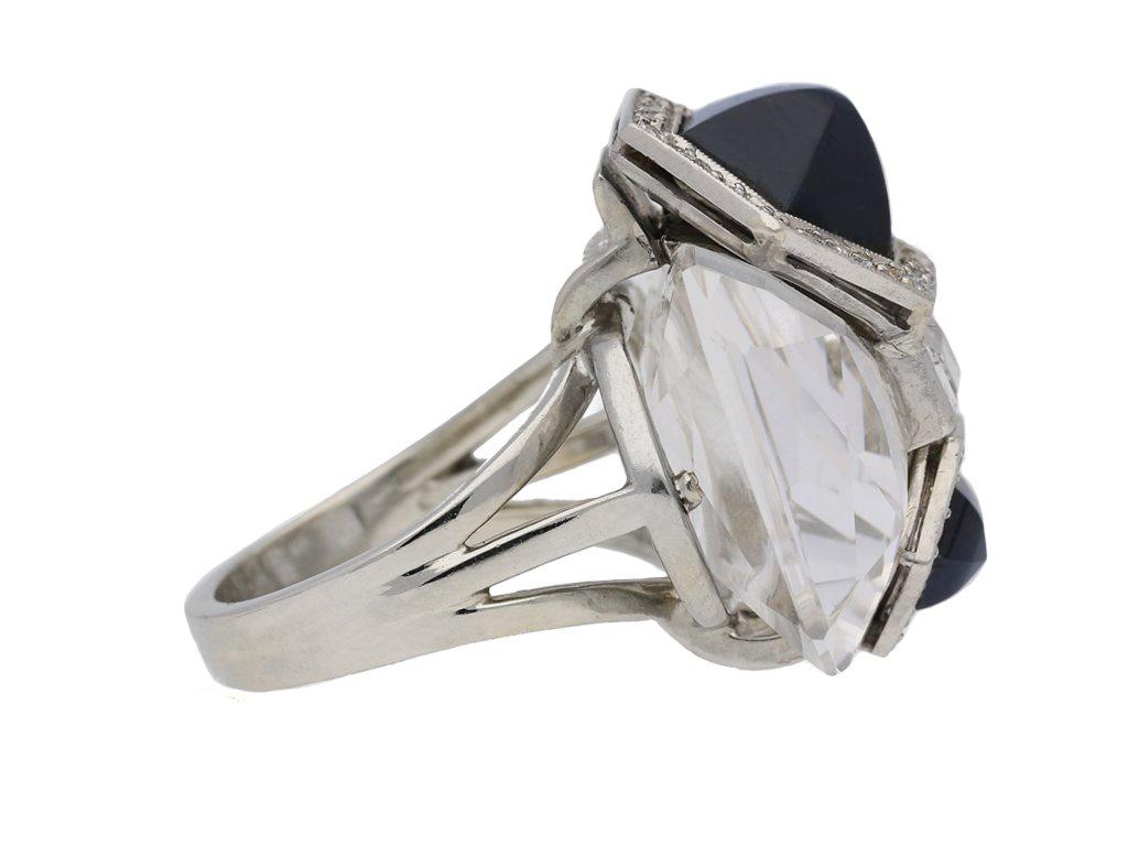 Sapphire, diamond and rock crystal ring, by Seaman Schepps circa 1940. A platinum and white gold ring vertically set with two hexagonal cabochon sapphires of differing sizes in collet settings with an approximate total weight of 4.00 carats, each