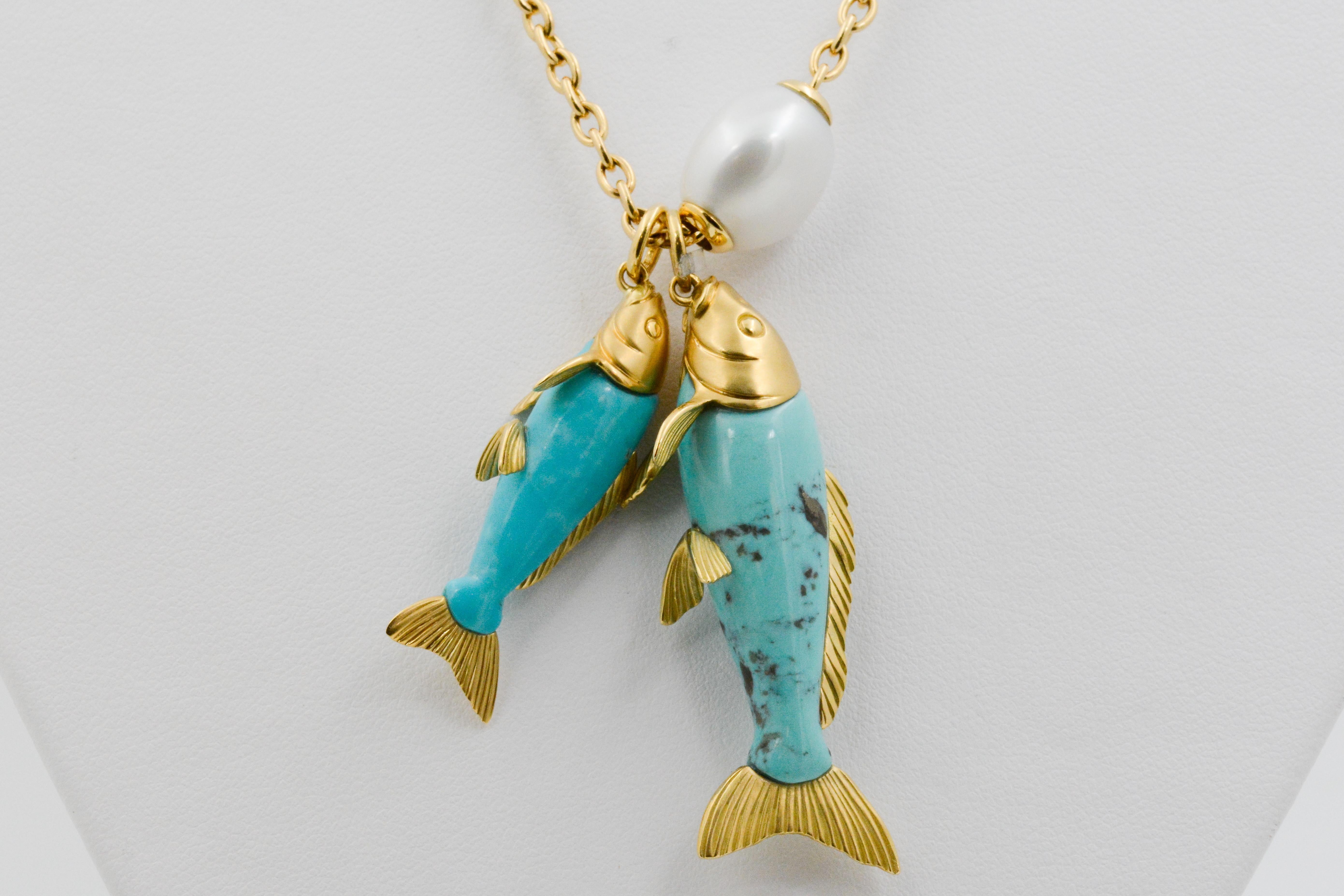 These Seaman Schepps turquoise koi fish charms are accented with 18 karat yellow gold heads and fins. They are strung on an 18 karat yellow gold 27 inch adjustable chain that features one pearl on the chain. One charm is larger than the other. Both