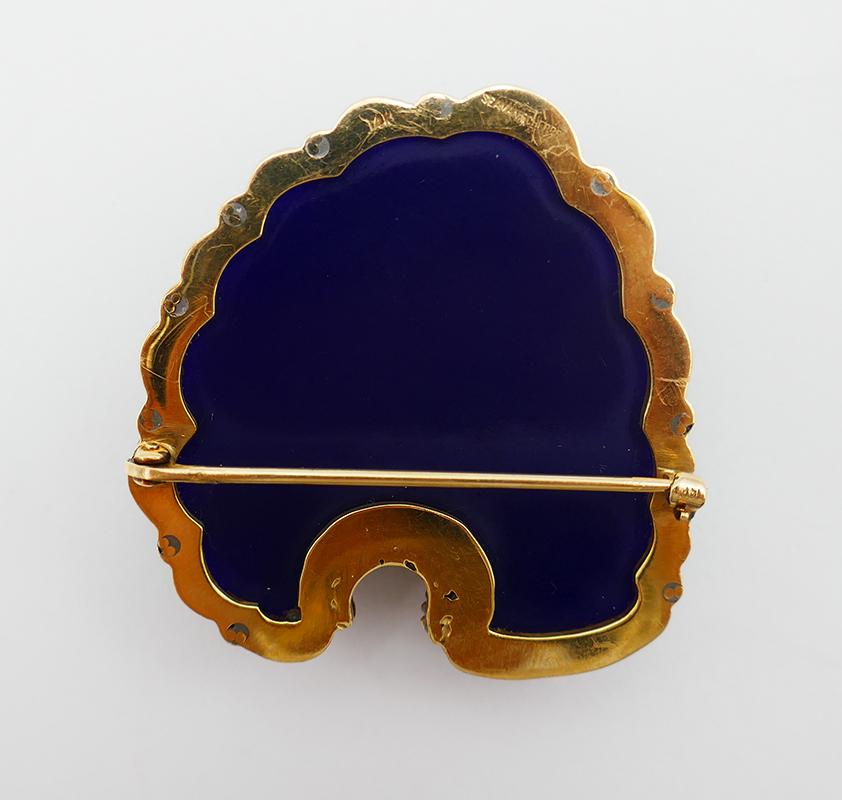         A beautiful vintage Seaman Schepps brooch made of Bakelite and 14k gold.
	The seashell is an iconic Schepps shape for brooches. This vintage brooch pin is crafted of a dark blue Bakelite set in a gold frame. Twisted gold threads underline