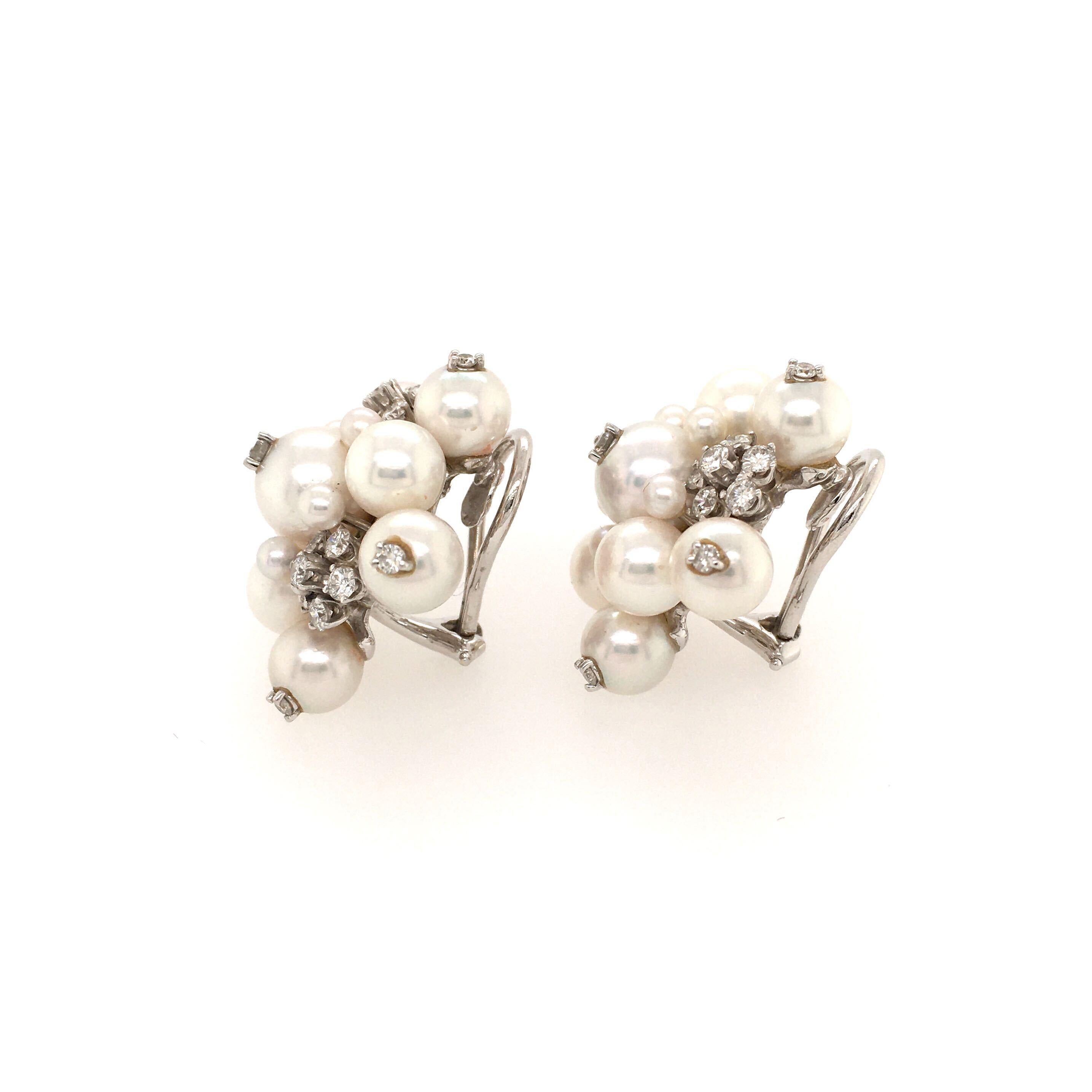 A pair of 18 karat white gold, pearl and diamond earclips, Seaman Schepps.  Designed as star shaped clusters of fourteen (14) pearls each, ranging in size from approximately 2.6 millimeters to approximately 7 millimeters,  each decorated with