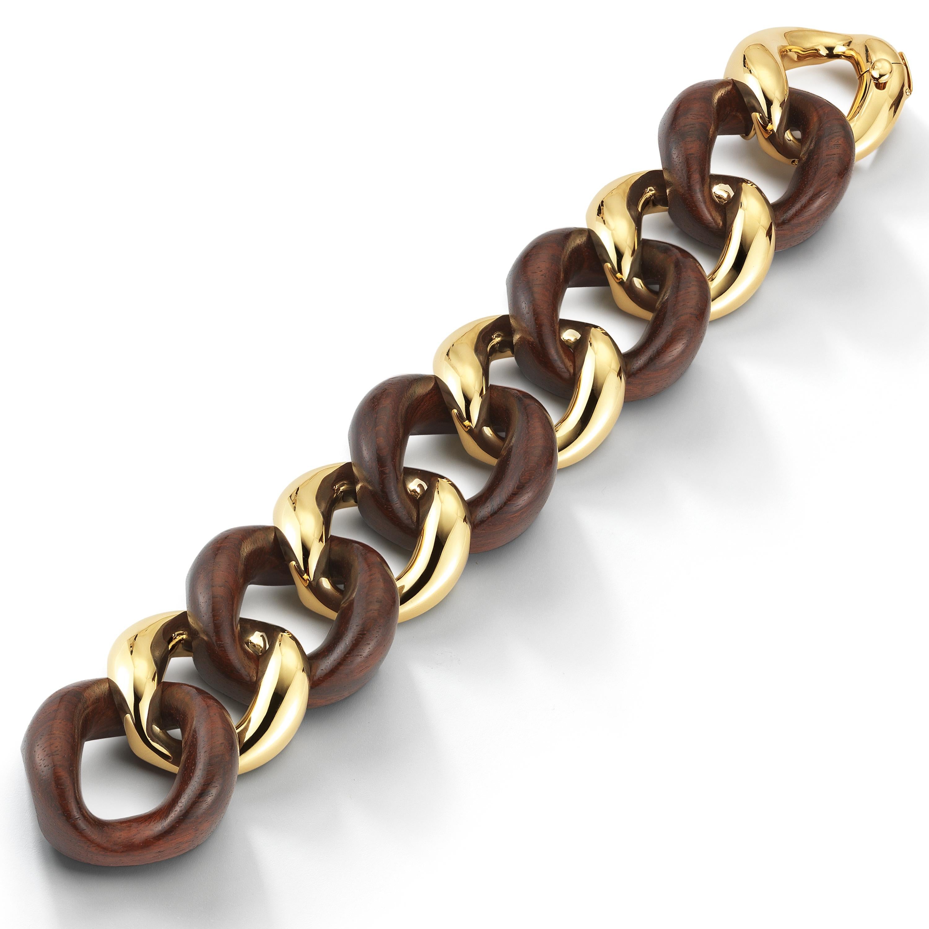 From Seaman Schepps, this hand carved walnut wood curb link bracelet also features 18k yellow gold. The bracelet measures at 7.5”. Signed Seaman Schepps.