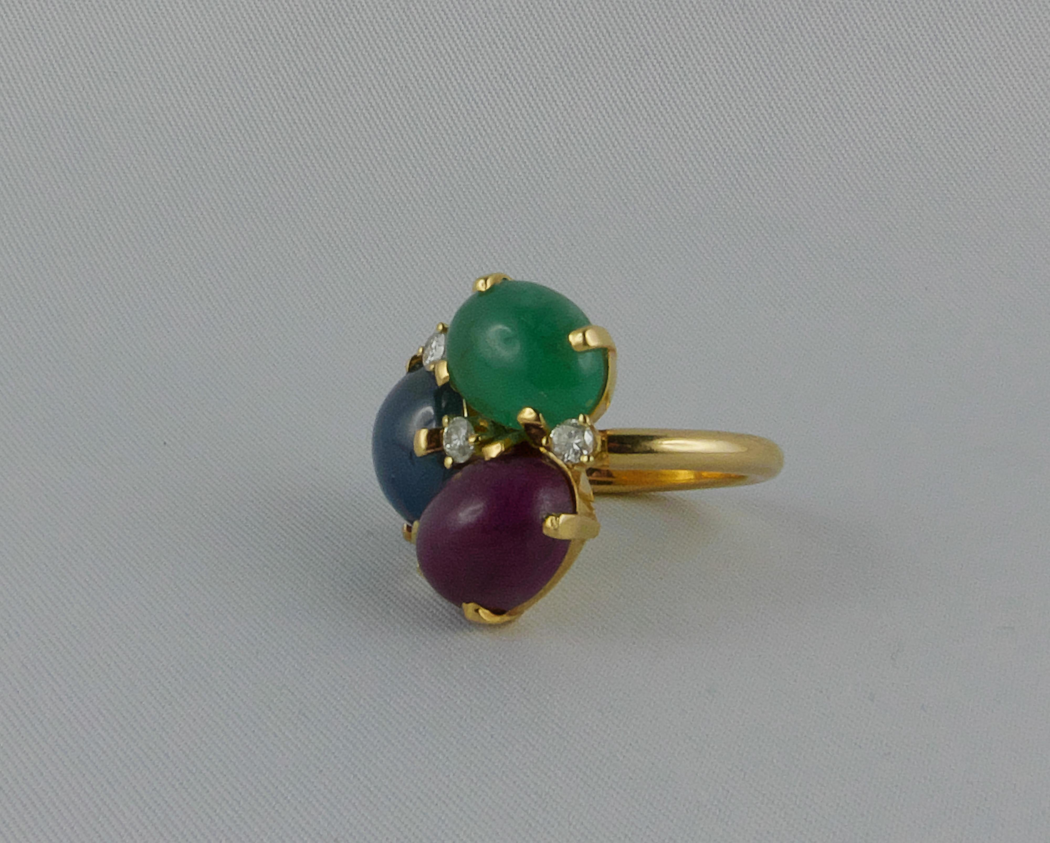 Glamourous Tutti Frutti Ring in Yellow Gold with 3 cabochon cut gems: Ruby, Sapphire and Emerald. The three gorgeous gems are set with 18k Yellow Gold and Diamonds to give sparkle and an extremely chic and sophisticated look. 
This delightful