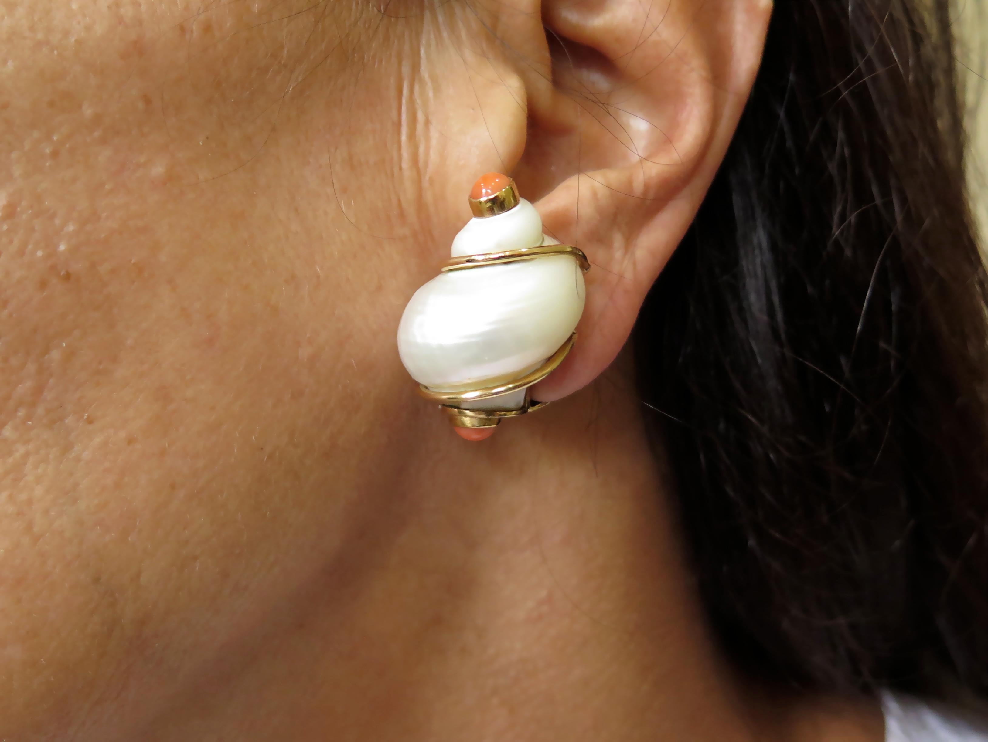 A pair of 14 karat yellow gold, turbo shell and coral earrings. Patricia Schepps Vaill of Seaman Schepps. Circa 1970.  Each set with a white turbo shell, terminating in a cabochon coral, enhanced by gold wire. Signed P.S.V. of Seaman Schepps. Length