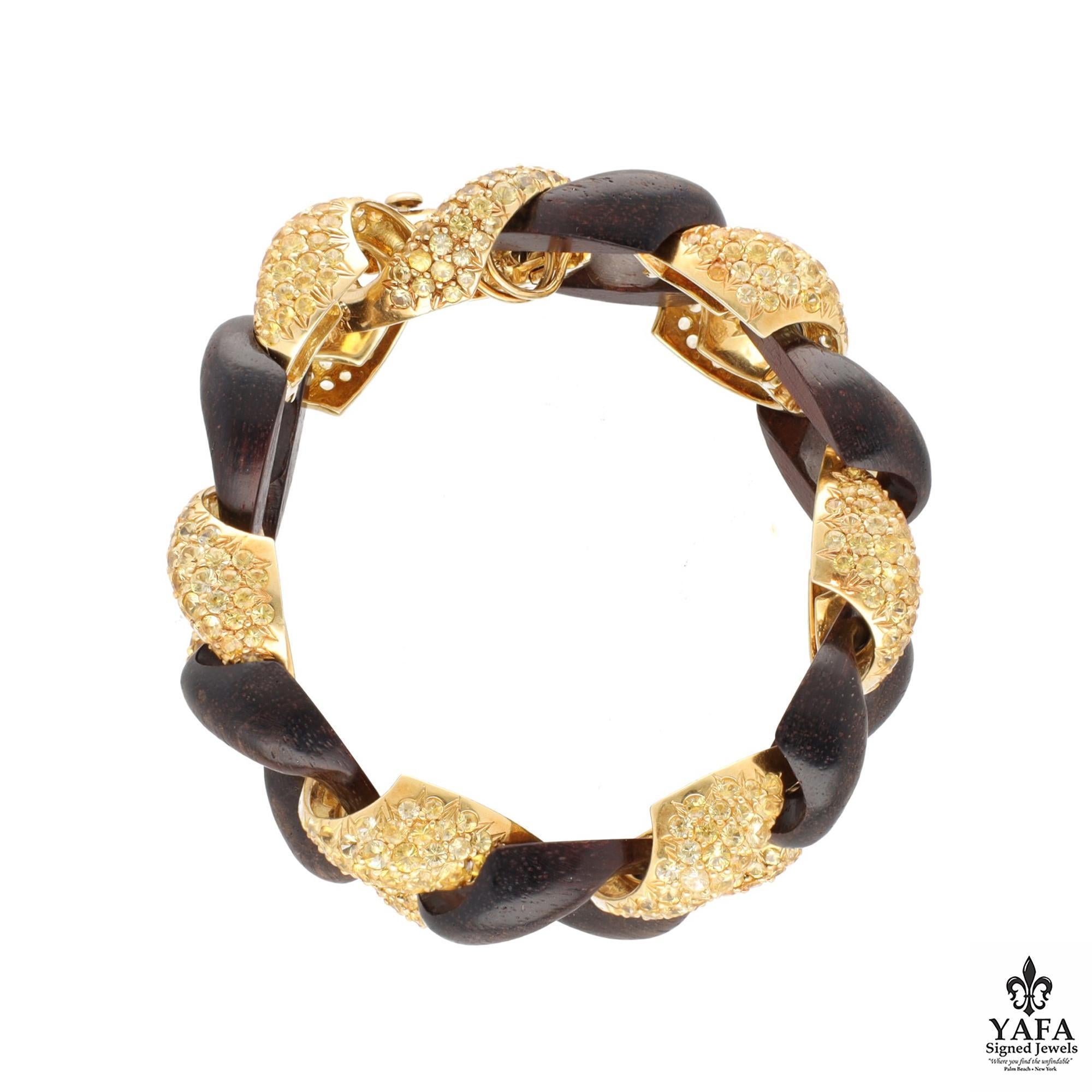 Exceptionally crafted by Seaman Schepps, comprising a vintage link bracelet crafted with interlocking links made of 18k yellow gold embellished with yellow sapphires and black wood, signed Seaman Schepps.