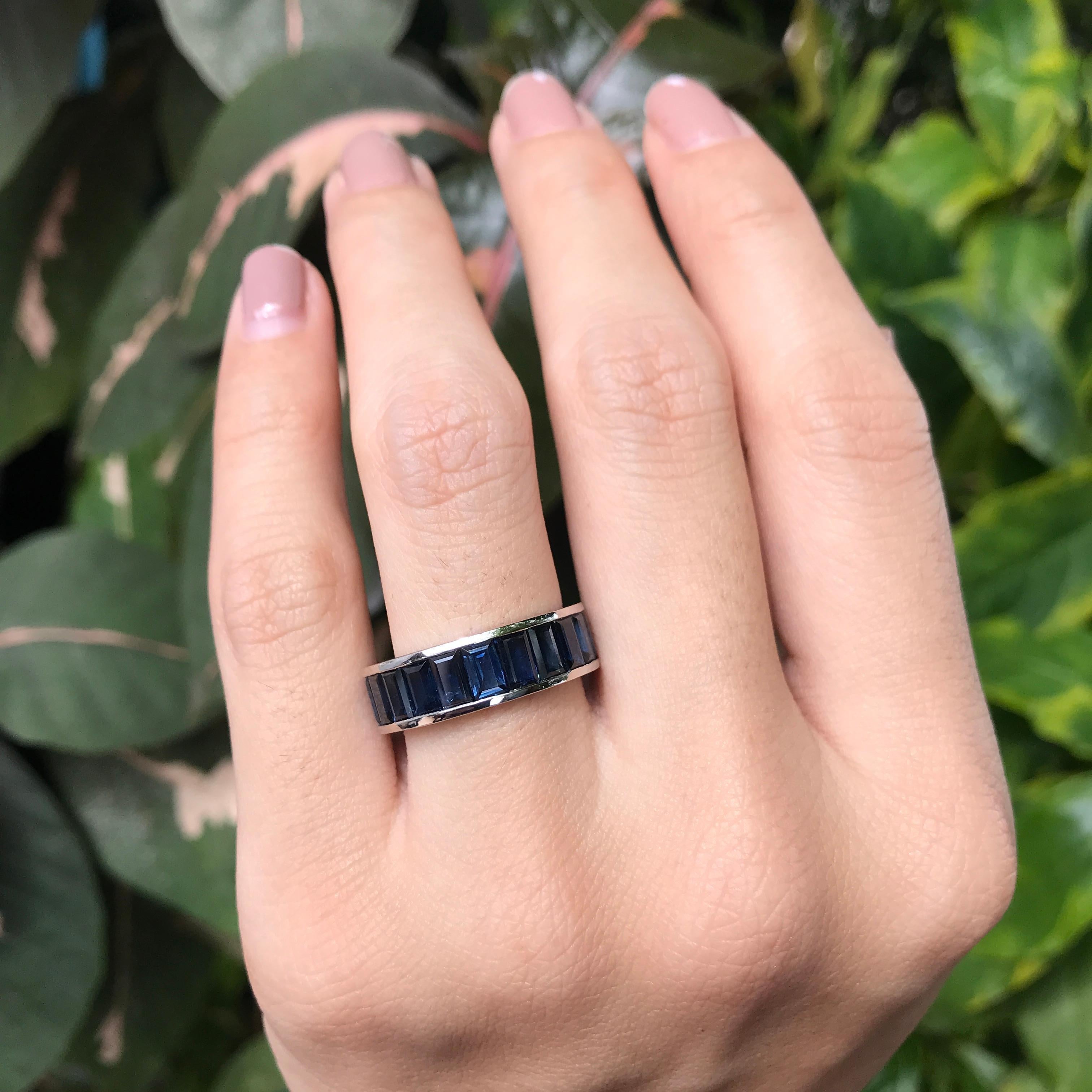 Cette bague d'éternité sans couture en saphir bleu baguette présente une bande continue de saphirs bleus radieux, chacun taillé en forme de baguette élégante pour créer un look sophistiqué et moderne. Le design sans couture assure un flux fluide et