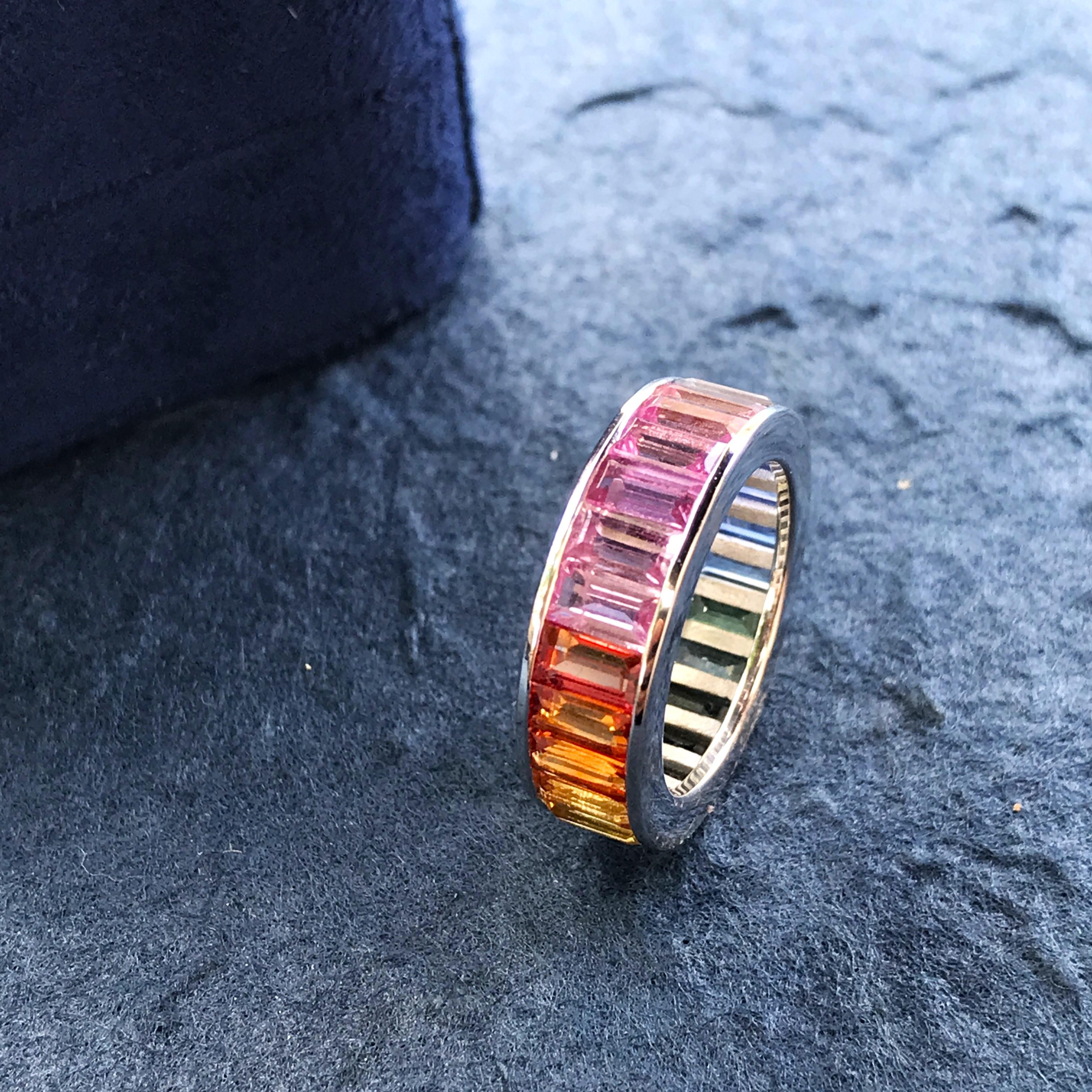 A unisex ring that can truly amp up the style of any outfit!

This rainbow sapphire eternity band is the perfect addition to your collection. Twenty-four baguette-cut rainbow sapphires are vertically set in18K white gold. The ring measures 6 mm.
