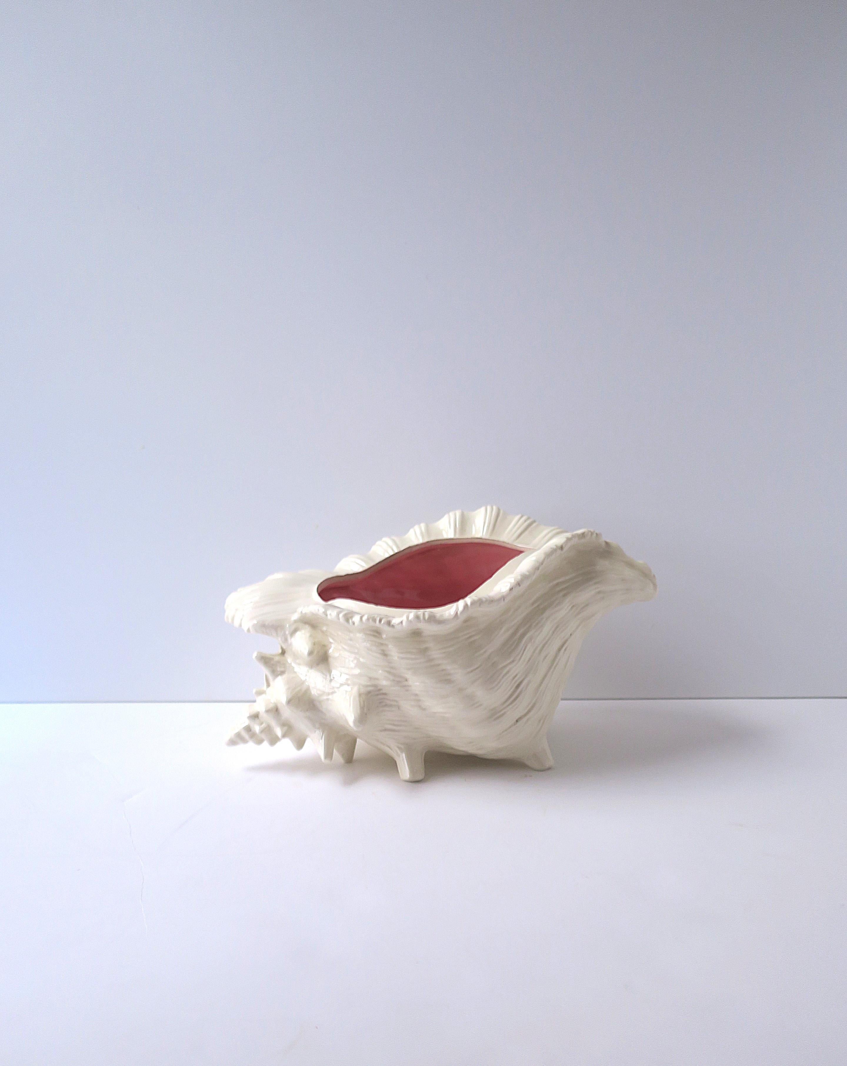 A relatively large ceramic conch seashell flower or plant planter, circa mid-20th century. Use as a standalone decorative object or as a planter (it's intended use.) This ceramic conch seashell planter has is textured white exterior and a dark pink