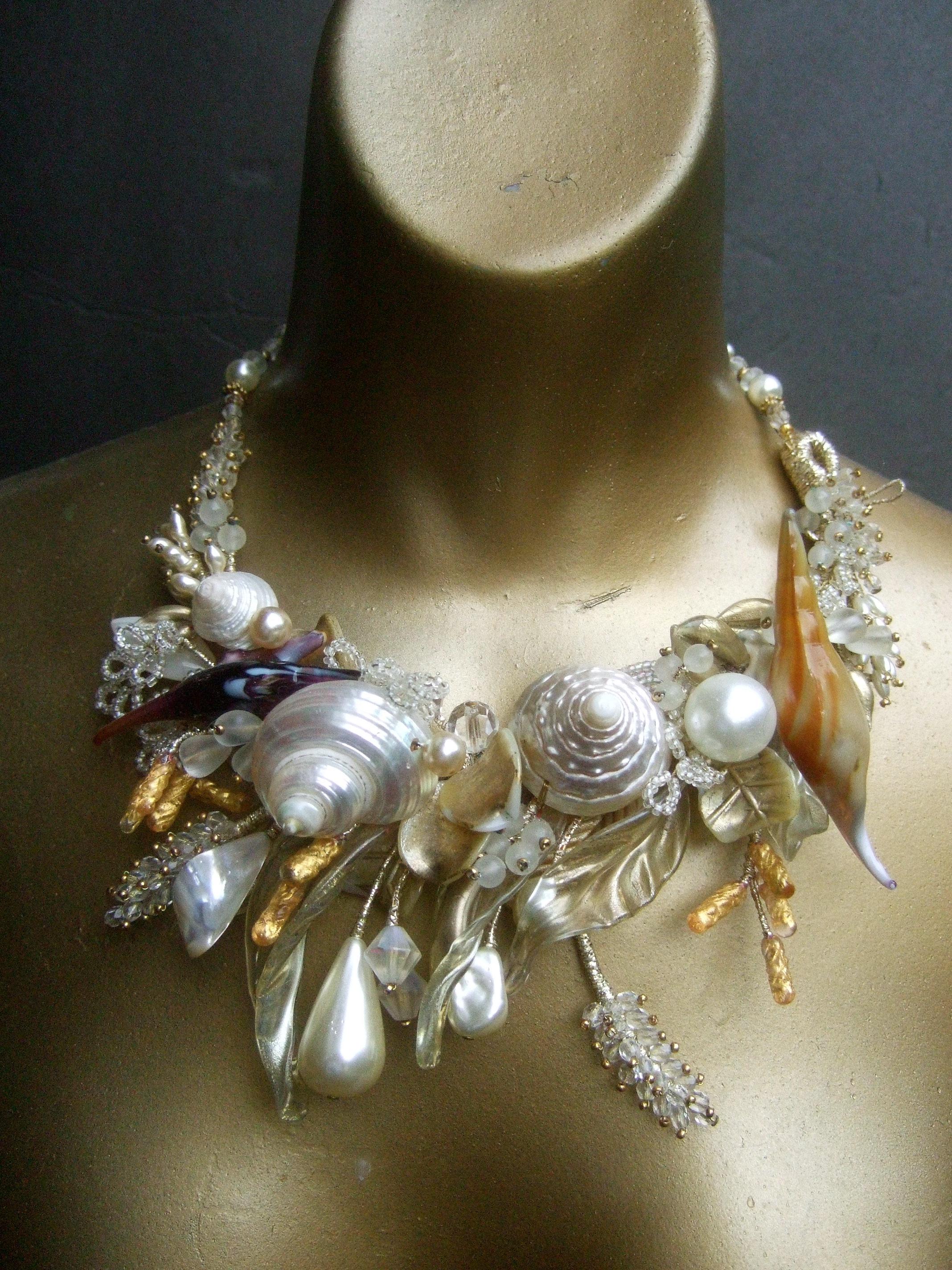Seashell handmade artisan choker band necklace c 1980s
The exquisite artisan choker is encrusted with a variety of seashells
Combined with faux resin enamel pearls & lucite beads & stalks 

The collection of embellishments are wired onto a rigid