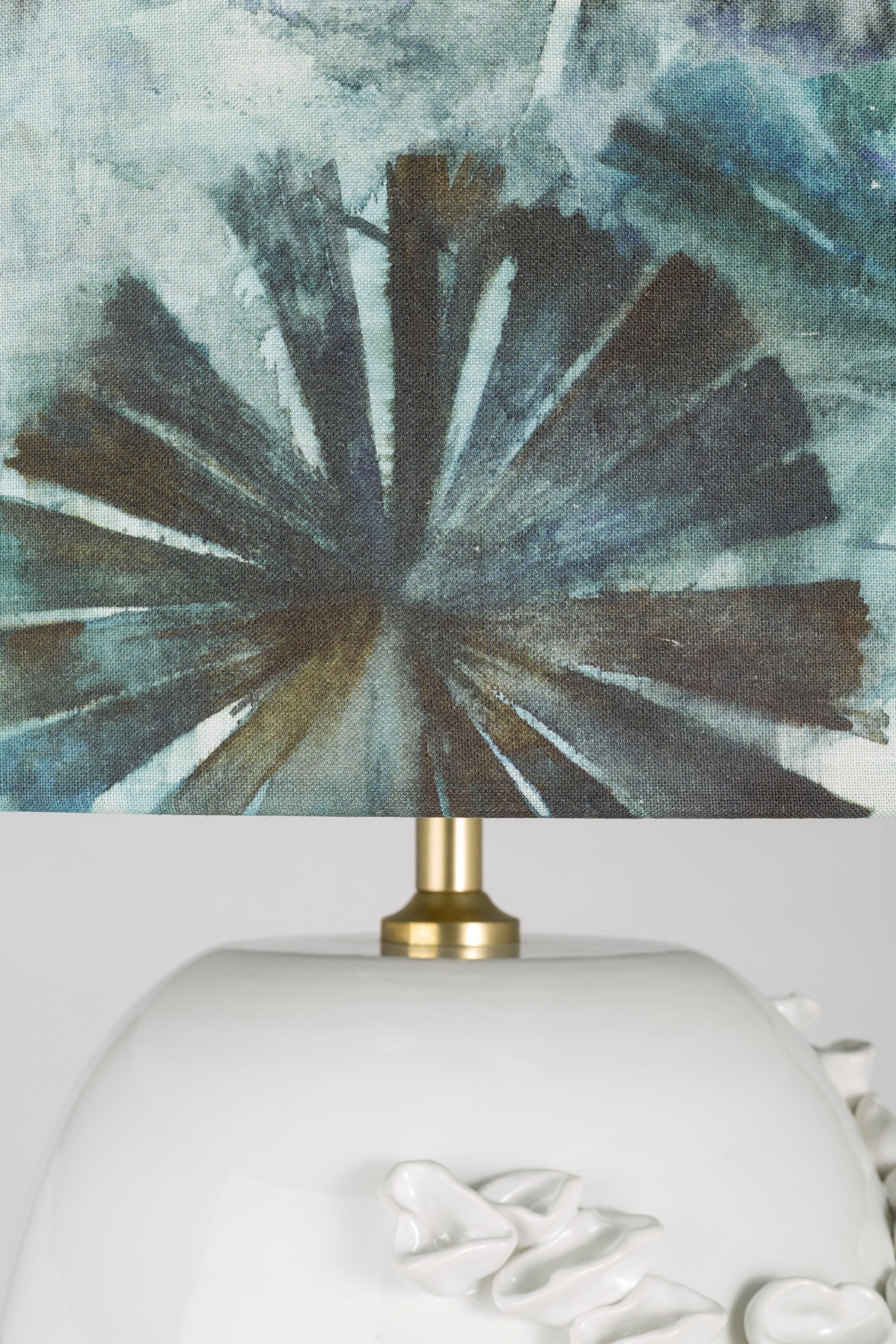 Bei der luxuriösen Serie der Seashell-Tischlampen dreht sich alles um den beeindruckenden Keramiksockel, der vom Mittelmeer inspiriert ist. Das Design bezieht die visuelle und taktile Wahrnehmung des Betrachters mit ein und bringt ihn dazu, die