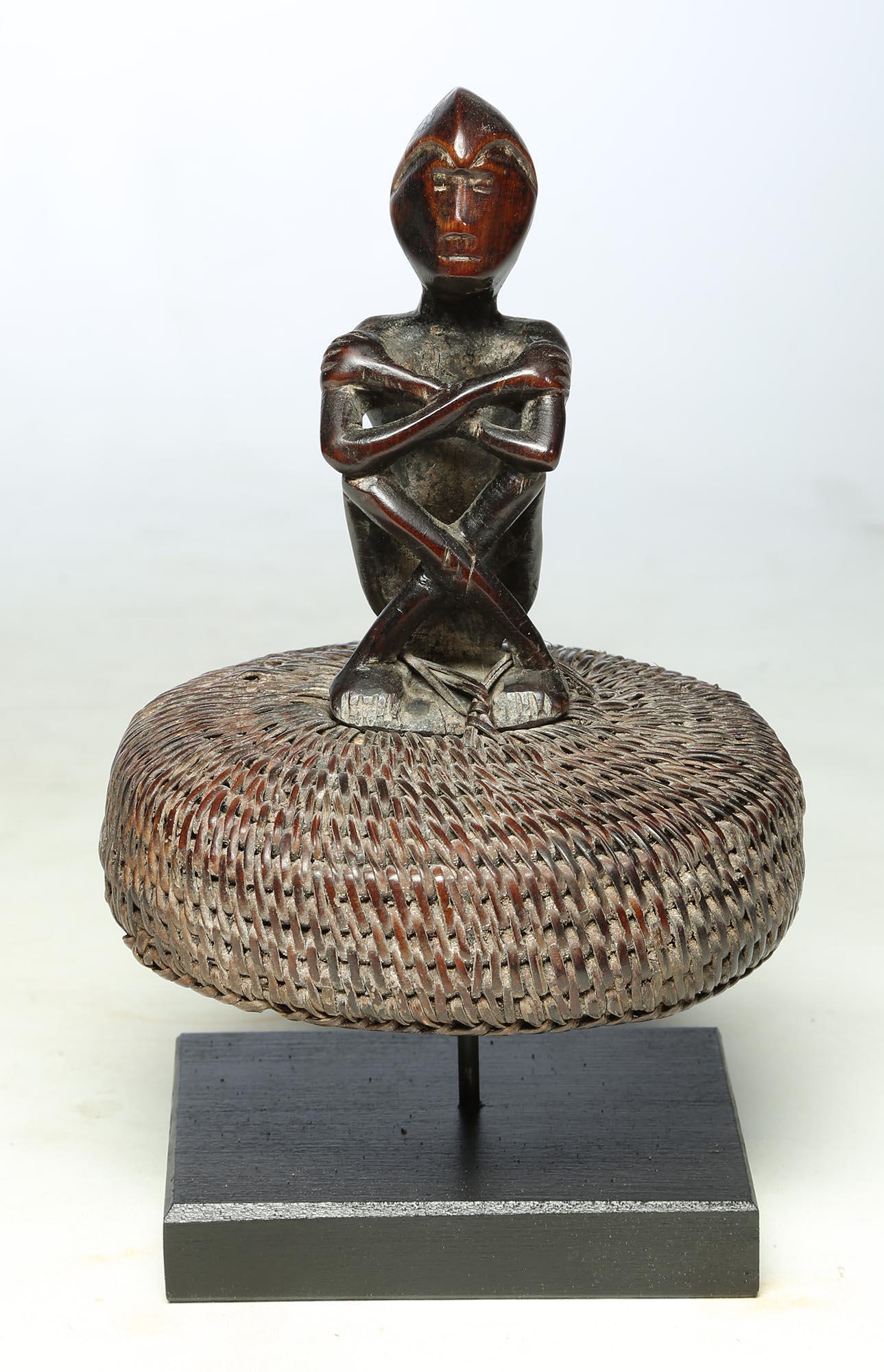 Hand-Carved Seated Philippine Miniature Bulul Figure Sitting on Old Hat or woven Basket Top For Sale