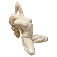 Sculpture féminine nue couchée assise