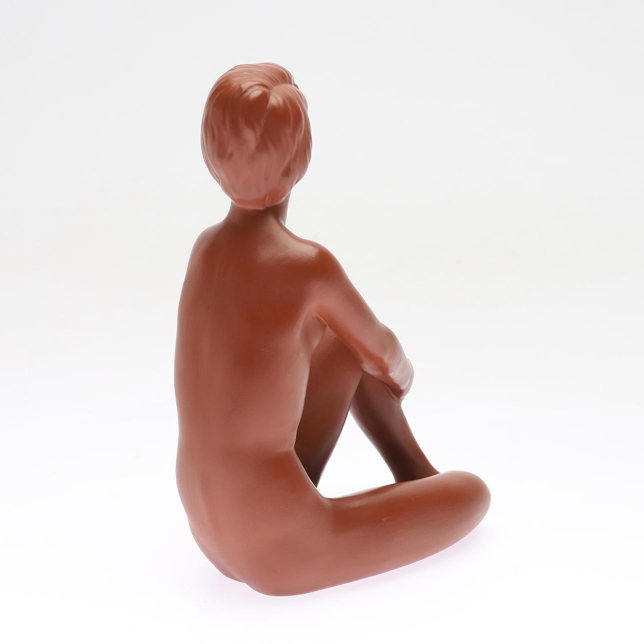 A detailed ceramic figurine showing a seating nude woman. Manufactured by Gmundner Kerami in the 1950s. 