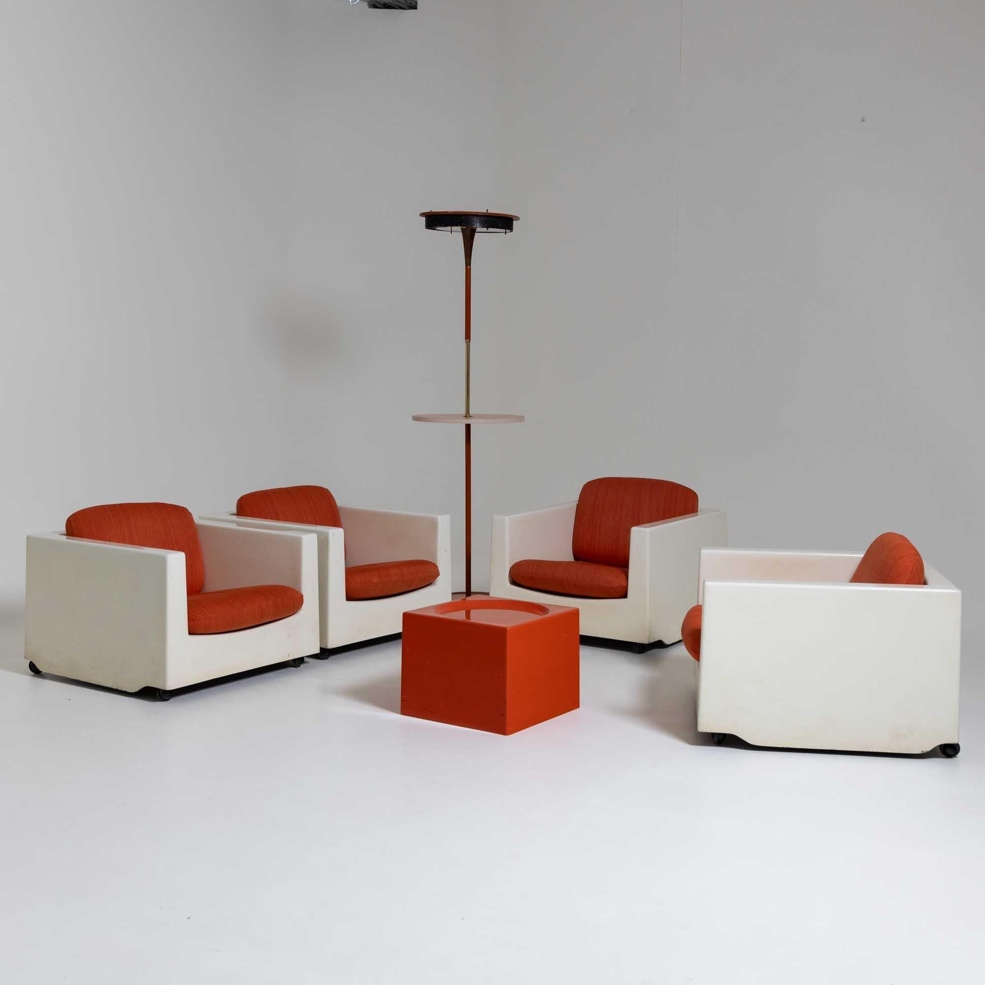 Mid-Century seating group consisting of four armchairs and a table: 33 x 41 x 41 cm. The armchairs are made of white plastic and are on castors. The cubic armchairs are equipped with two orange covered cushions. The likewise cubic coffee table with