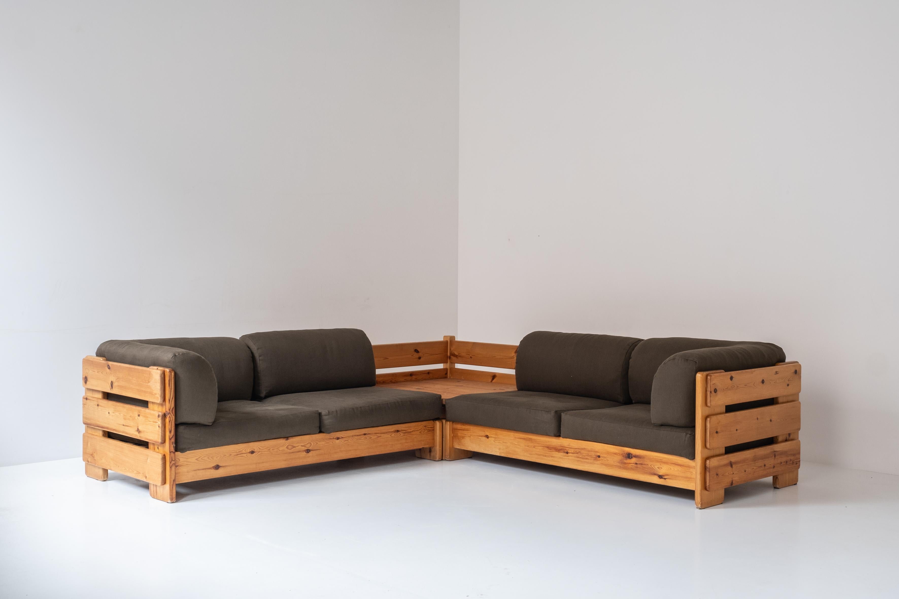 Groupe de sièges français, conçu et fabriqué dans les années 1960. Ce canapé d'angle est fabriqué en lattes de pin massif et les coussins sont fraîchement retapissés dans un tissu vert. Comme cette unité se compose de trois éléments individuels,