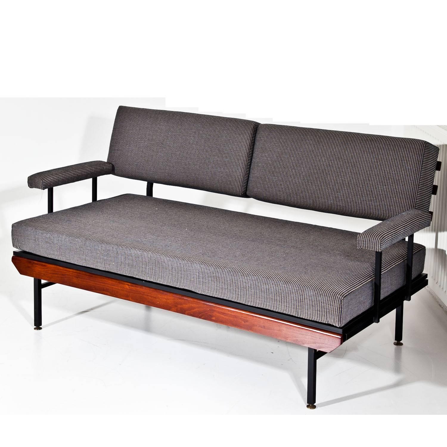 Seating group, consisting of two two-seat sofas and two armchairs of the mid-20th century. The sofas and armchairs stand on black iron feet and each armrest is supported by two iron bars. The backrests are rectangular cushions and the upholstery is