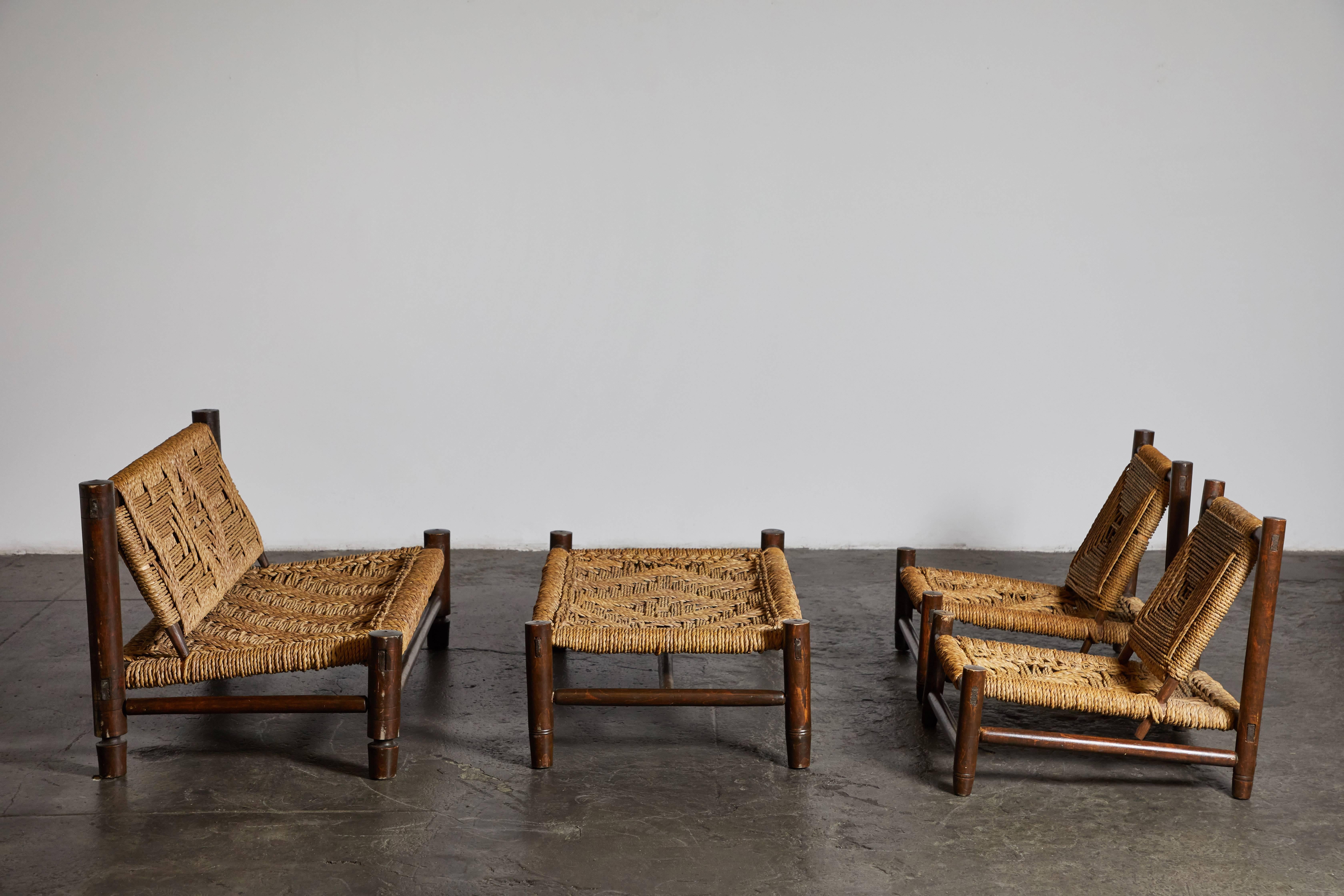 Stained beech and abaca rope set by Adrien Audoux and Frida Minet. Made in France, circa 1950s.
All pieces sold separately. Chairs sold as a pair. 

Chairs
Dimensions 25.8” H x 24.5” W x 27” D 

Bench
Dimensions 14” H x 45.5” W x 27” D